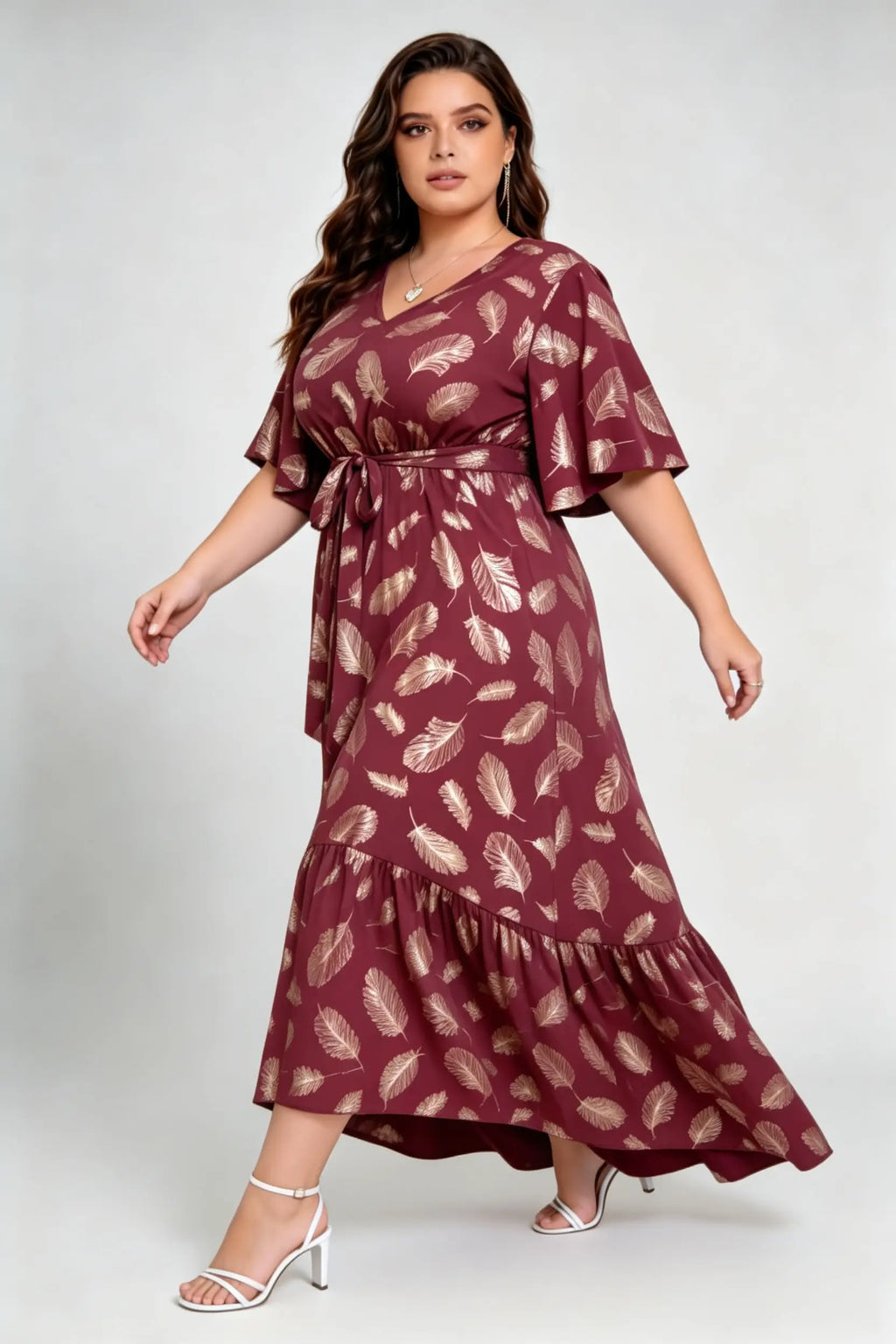 Curvy model wearing plus size wine red gold foil feather print maxi dress, v-neck flare sleeve high-low hem belted elegant summer dress
