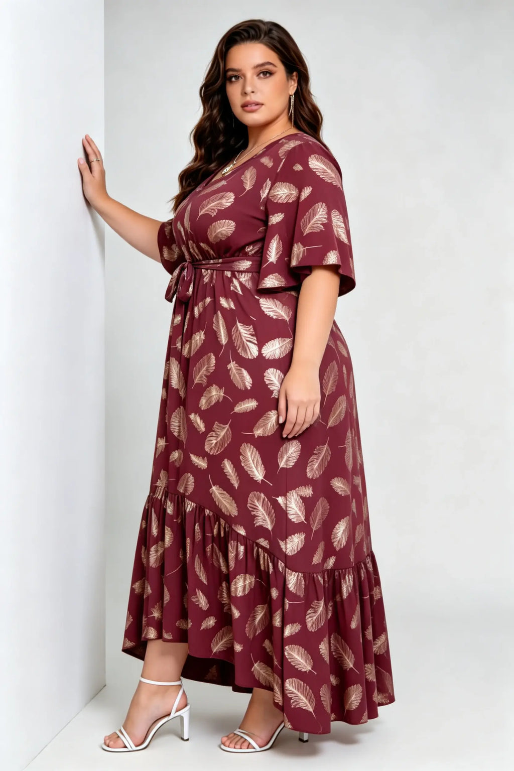 Curvy model wearing plus size wine red gold foil feather print maxi dress, v-neck flare sleeve high-low hem belted elegant summer dress