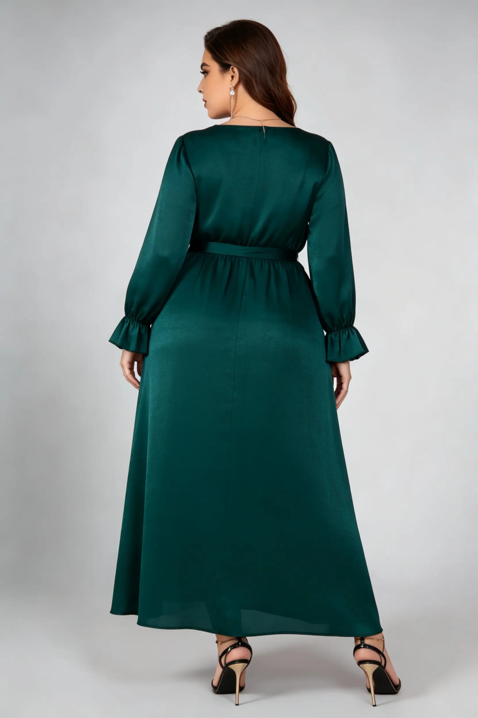 Curvy model wearing plus size dark green satin maxi dress, v-neck long sleeve ruffle cuff belted a-line elegant evening dress