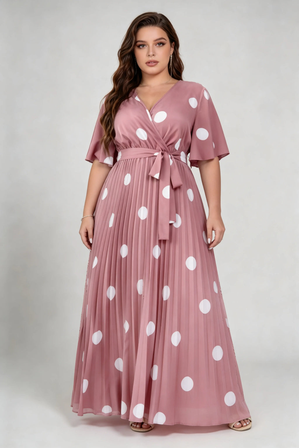 Curvy model wearing plus size pink polka dot pleated maxi dress, v-neck flutter sleeve belted chiffon a-line elegant summer dress