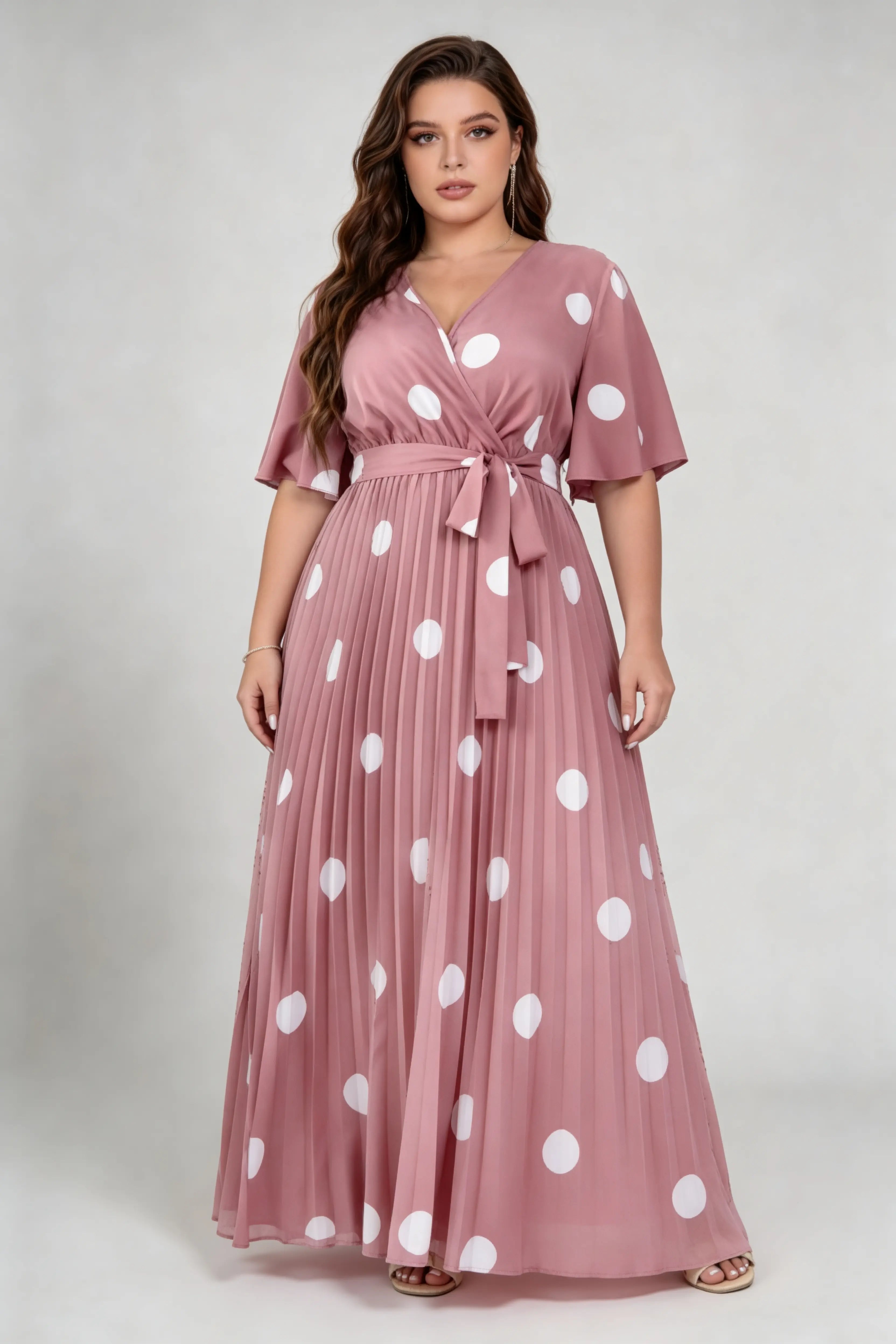 Curvy model wearing plus size pink polka dot pleated maxi dress, v-neck flutter sleeve belted chiffon a-line elegant summer dress