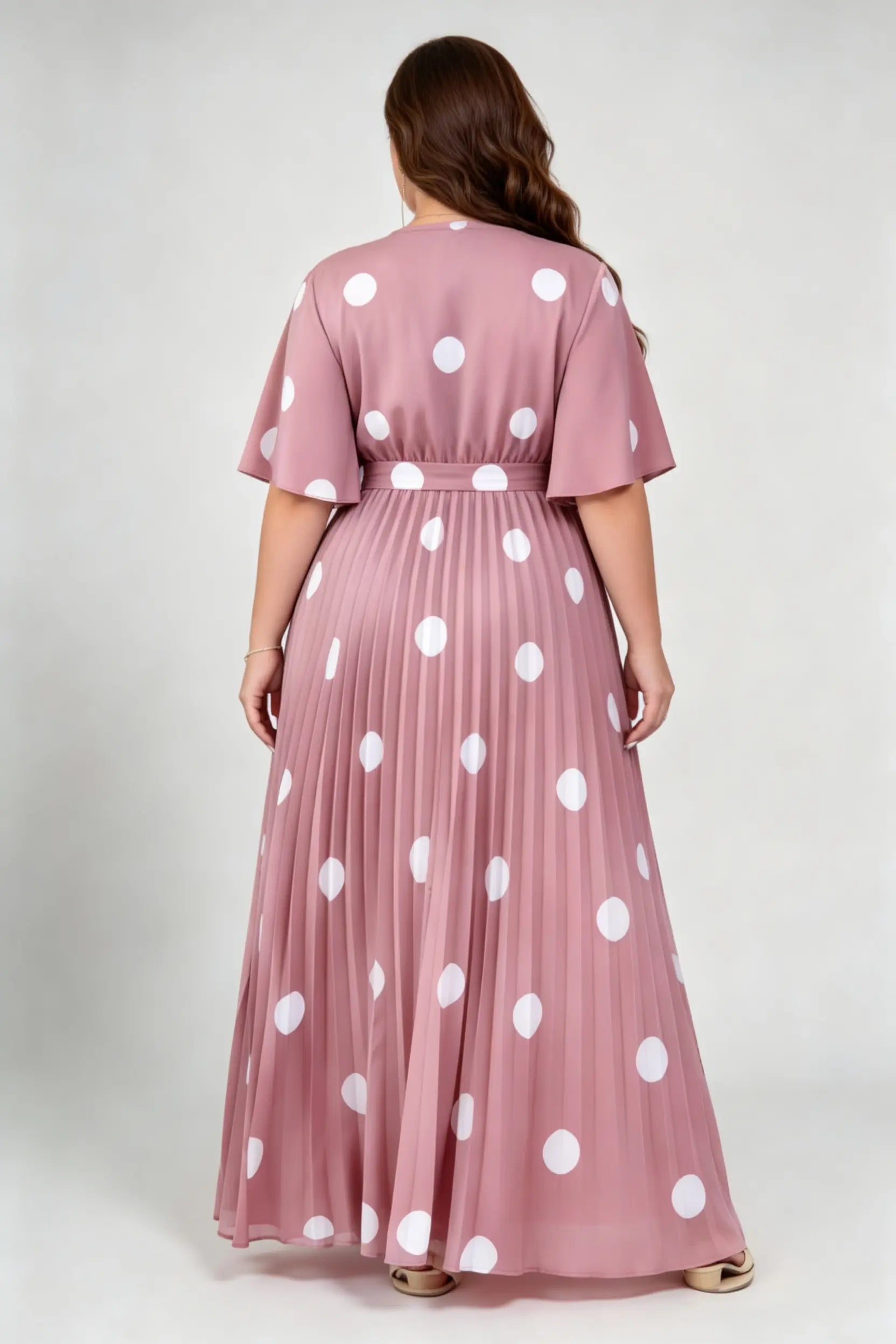 Curvy model wearing plus size pink polka dot pleated maxi dress, v-neck flutter sleeve belted chiffon a-line elegant summer dress