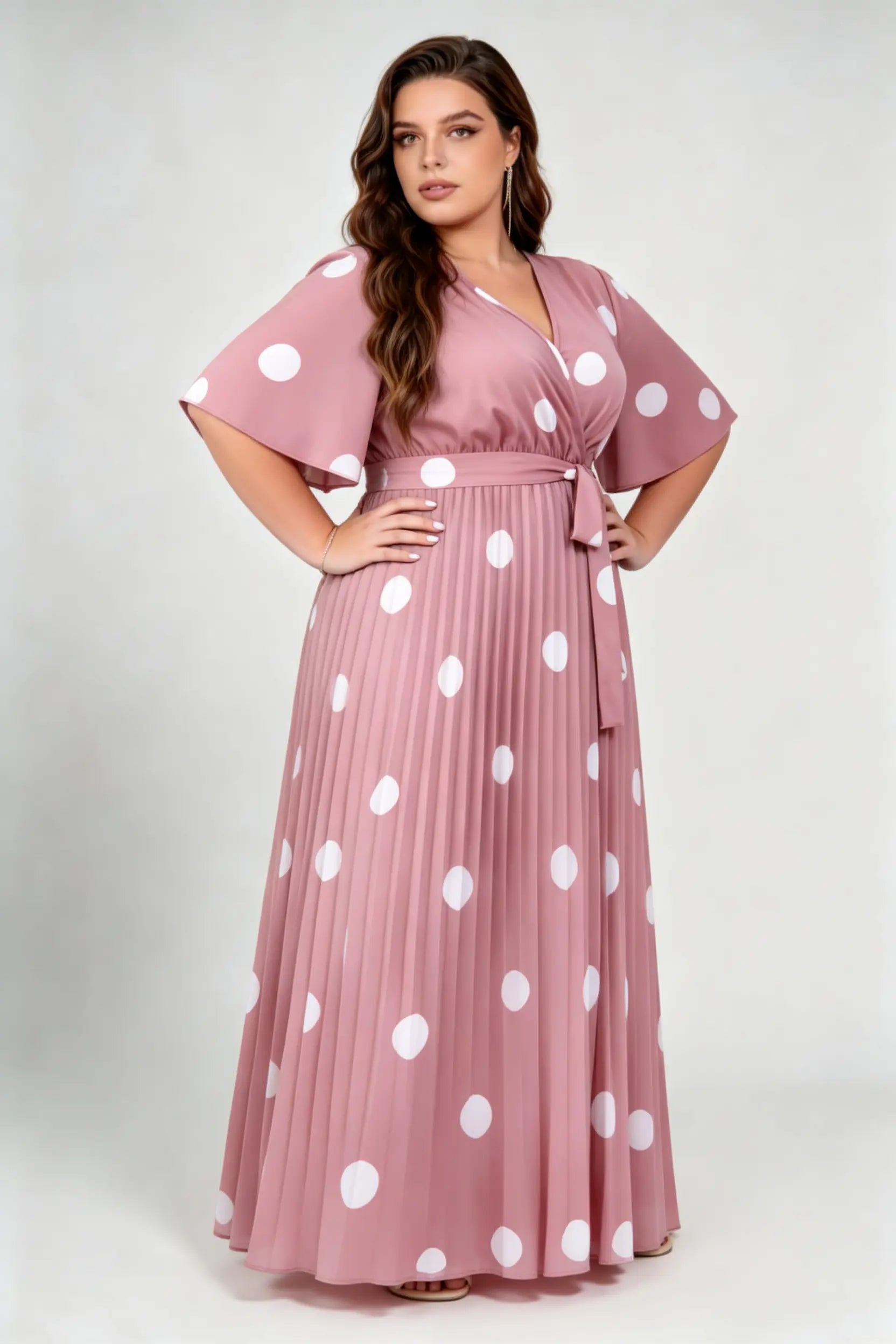 Curvy model wearing plus size pink polka dot pleated maxi dress, v-neck flutter sleeve belted chiffon a-line elegant summer dress