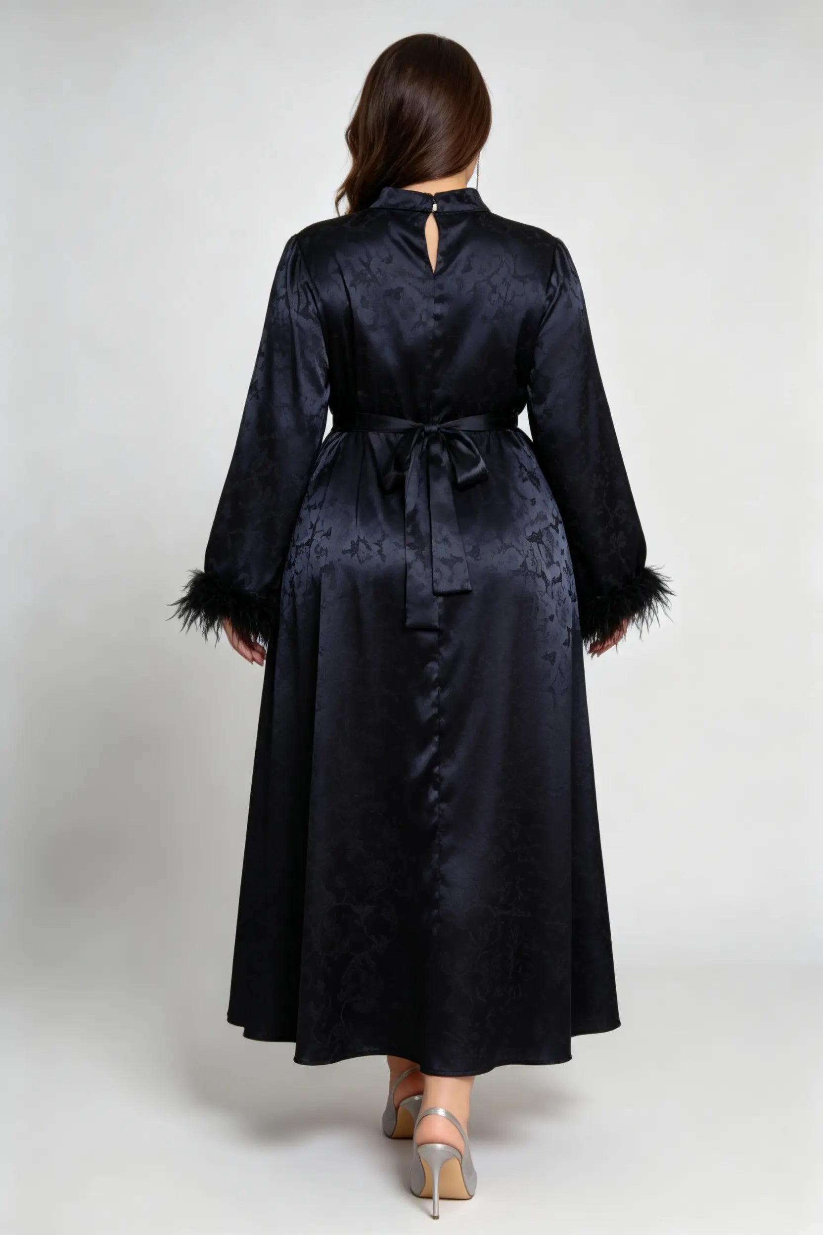 Curvy model wearing plus size black jacquard feather cuff maxi dress, stand collar long sleeve back tie a-line formal dress