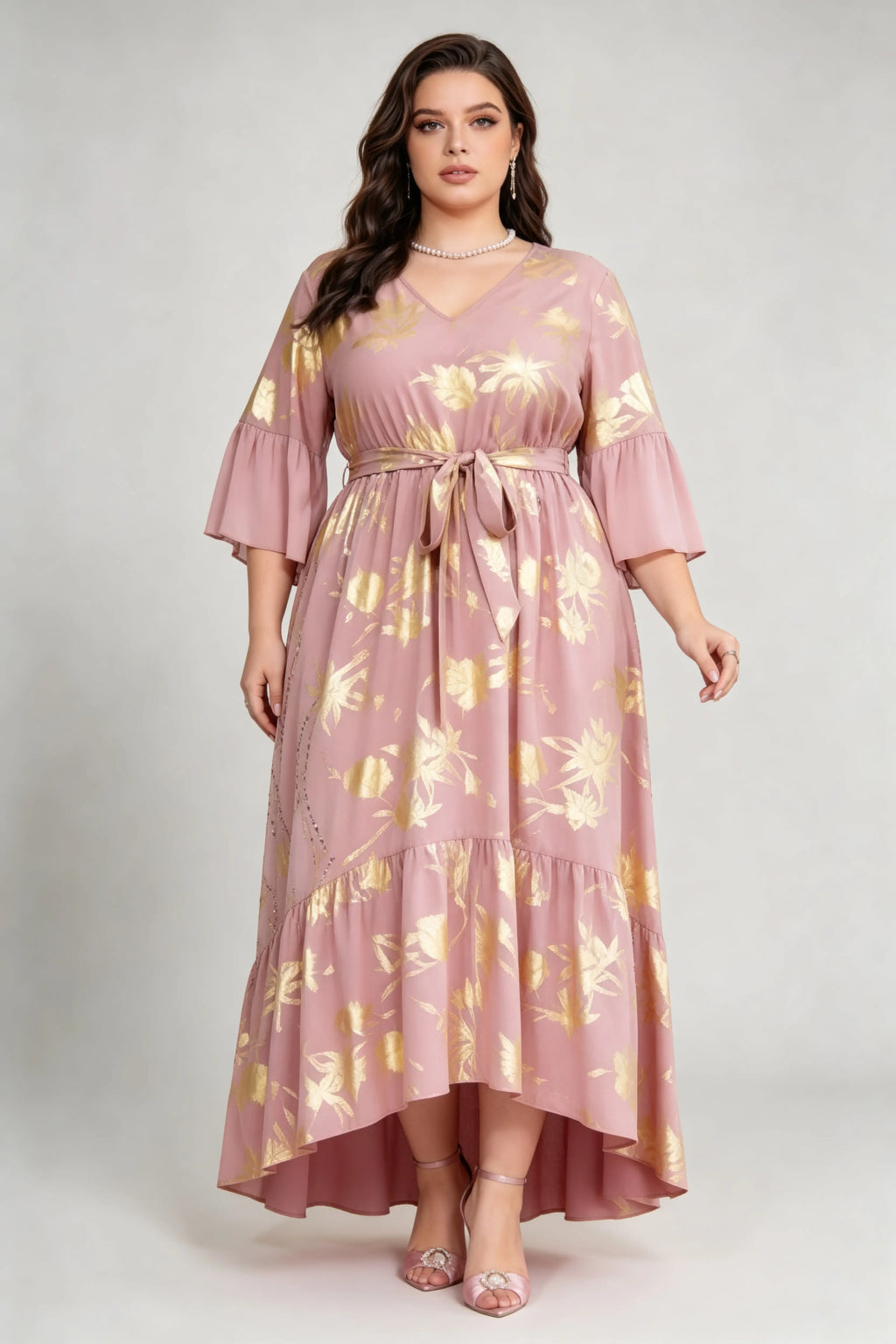 Curvy model wearing plus size blush pink gold foil floral maxi dress, v-neck 3/4 ruffle sleeve self-tie belted a-line high-low dress