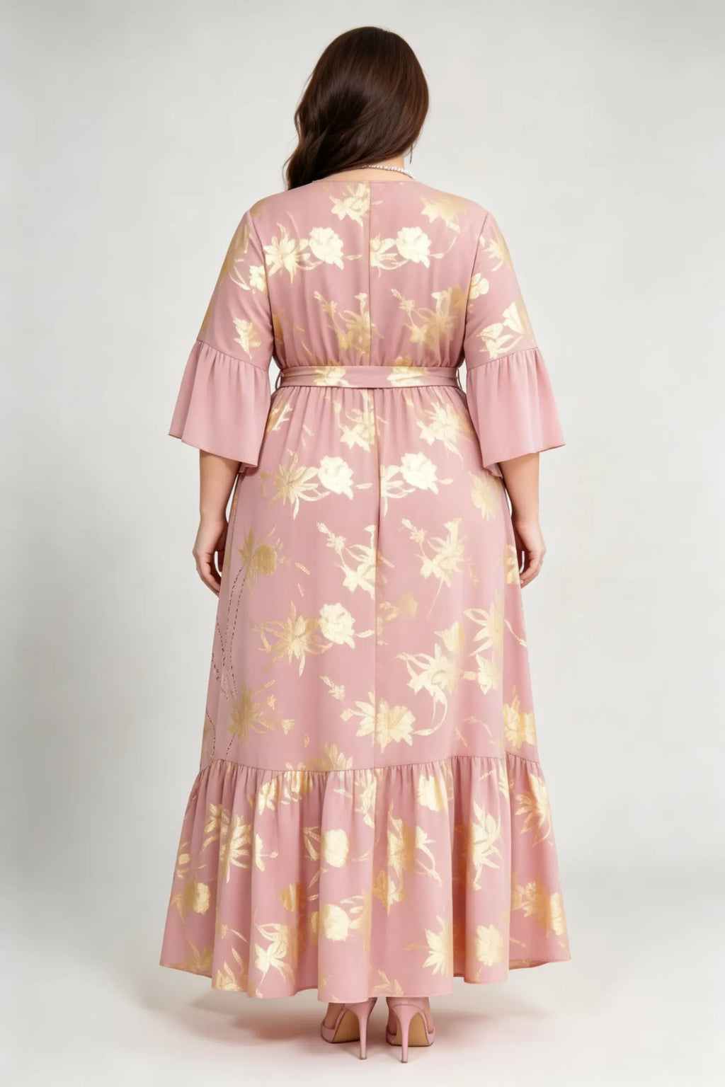 Curvy model wearing plus size blush pink gold foil floral maxi dress, v-neck 3/4 ruffle sleeve self-tie belted a-line high-low dress