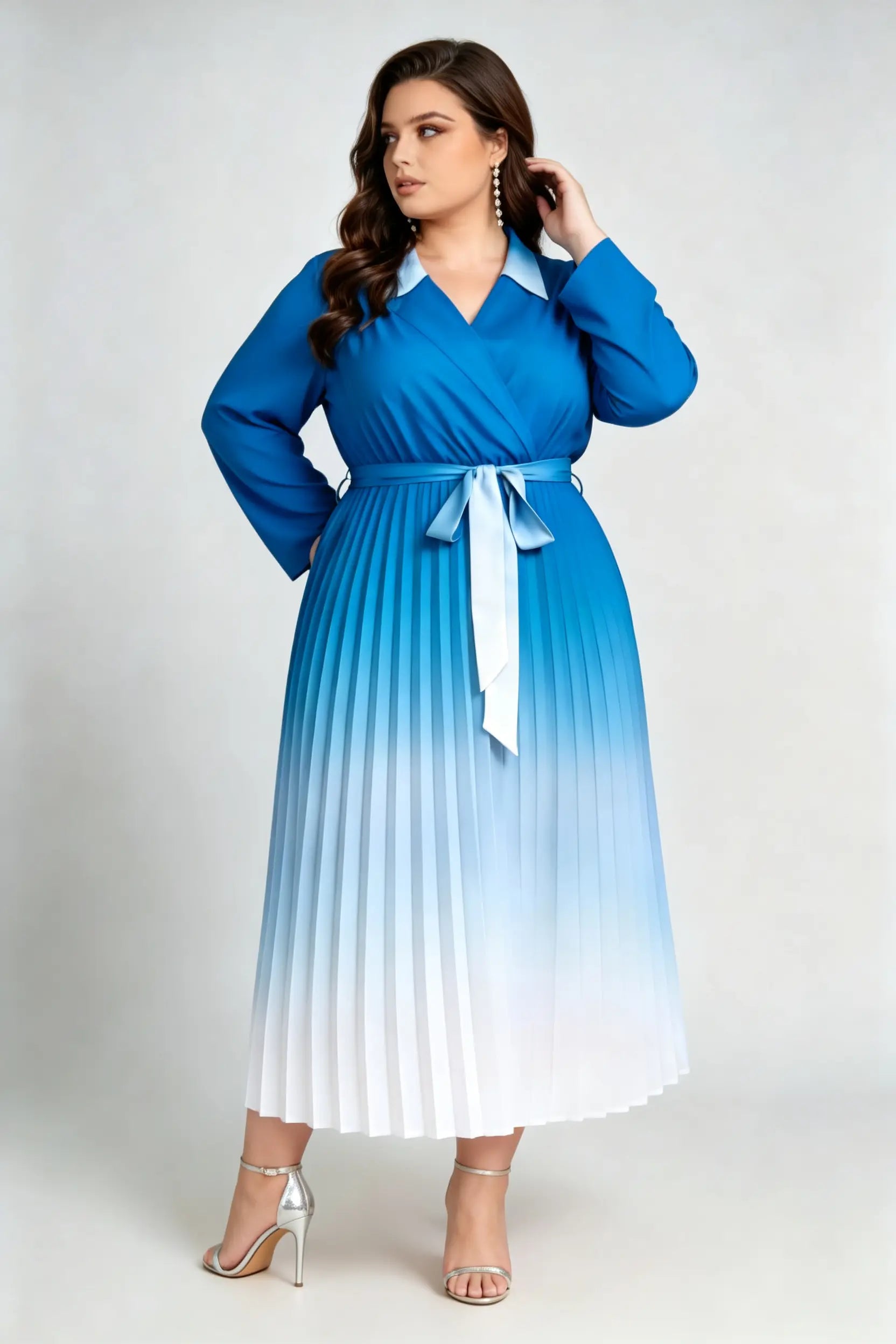 Curvy model wearing plus size blue gradient pleated midi dress, lapel collar wrap v-neck long sleeve belted a-line work dress