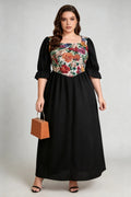Curvy model wearing plus size floral print square neck maxi dress, black a-line with puffed sleeves, elegant summer dress