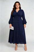 Curvy model wearing plus size navy blue wrap midi dress, notched lapel blazer style with flounce sleeves and waist tie
