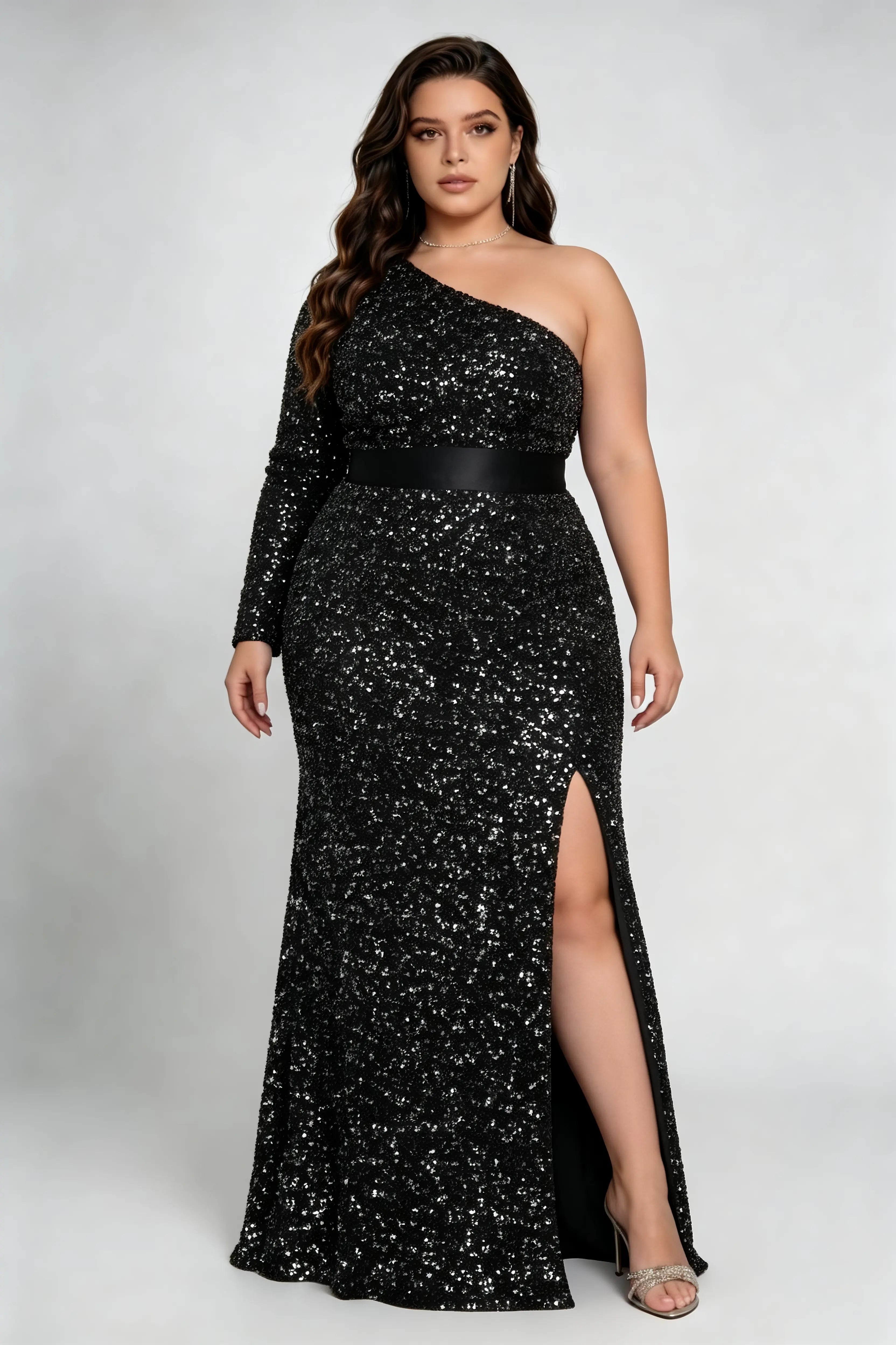 Curvy model wearing plus size black sequin one-shoulder mermaid evening gown with satin waistband and slit