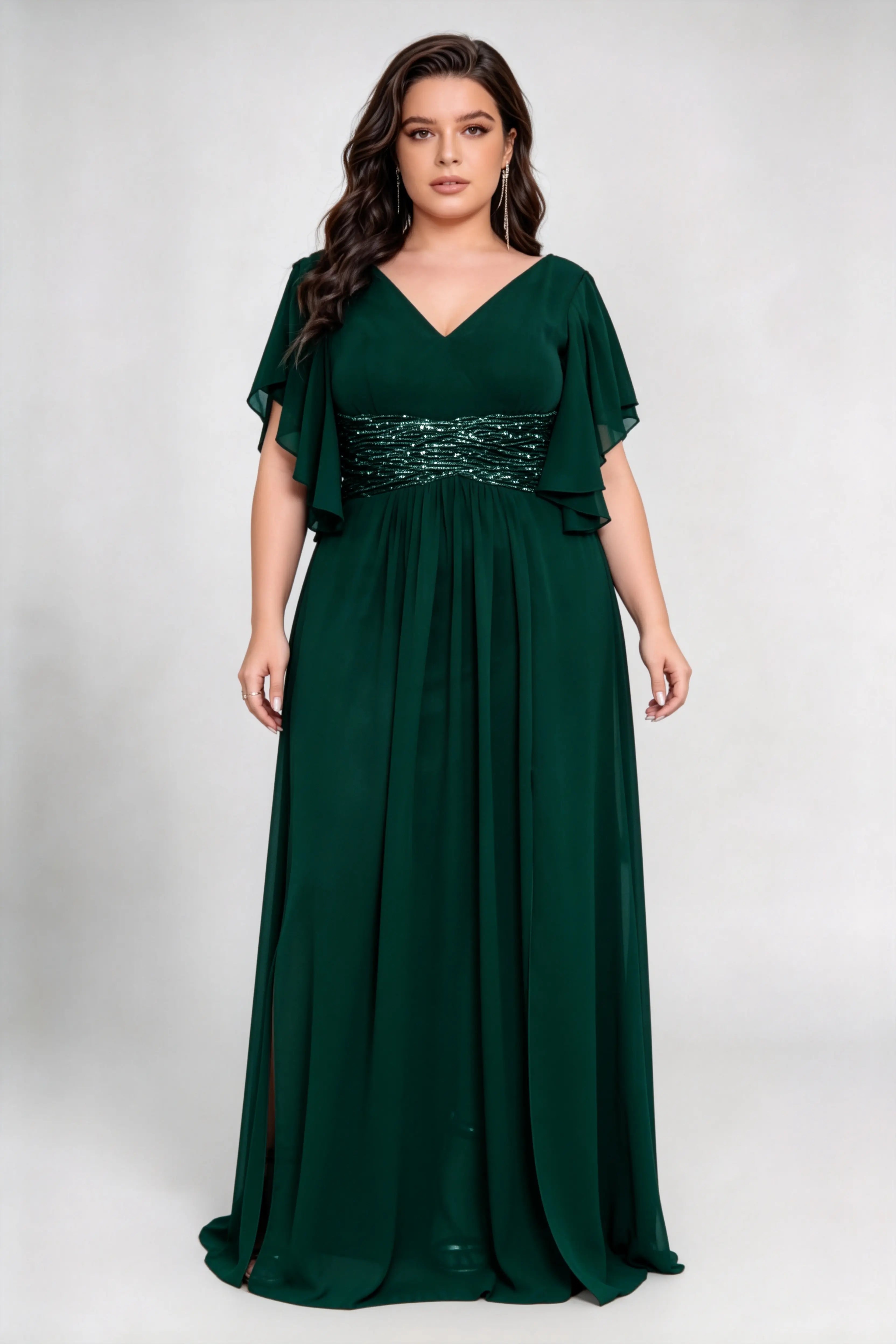 Curvy model wearing plus size green v neck flutter sleeve ruched sequin waist chiffon high split maxi bridesmaid formal evening dress