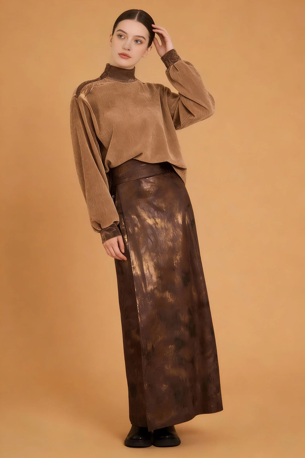 Woman wearing a brown long-sleeve top and leather skirt against a beige background