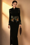 Woman wearing Elegant Black Qipao-Inspired Maxi Dress with Embroidery against a beige wall