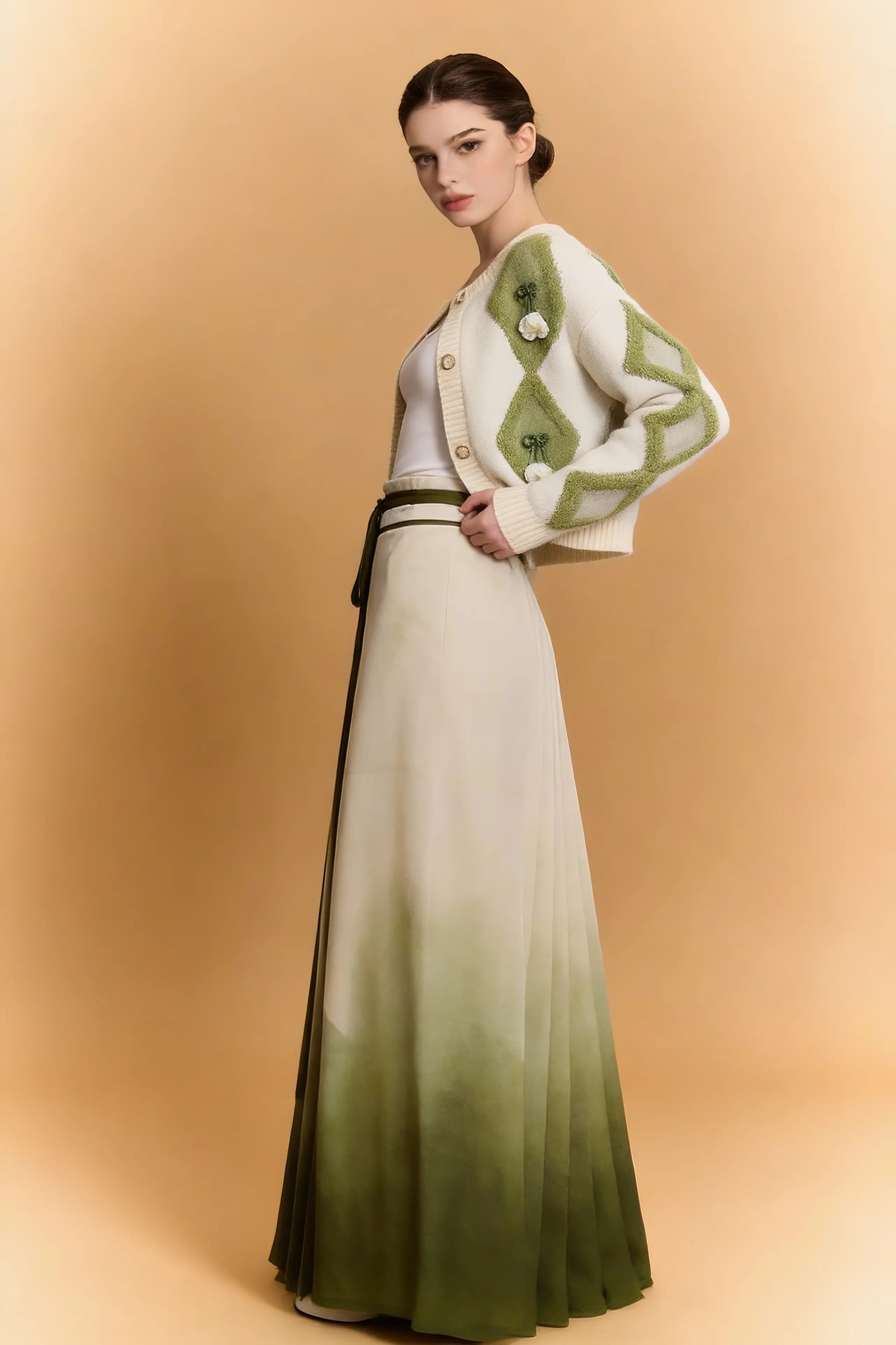 Woman wearing a Green & White Argyle Knit Cardigan with Pleated Ombre Skirt Set on a beige background