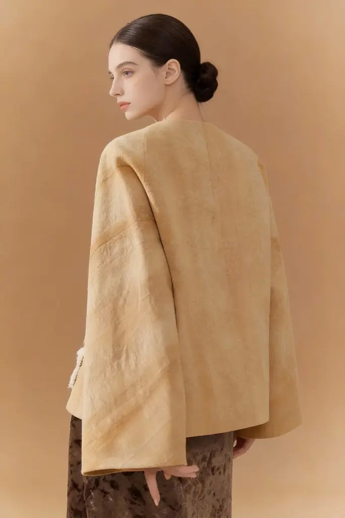 Woman wearing a Artisan Embroidered Linen Jacket with Bird Motifs - Beige Handcrafted Outerwear on a brown background