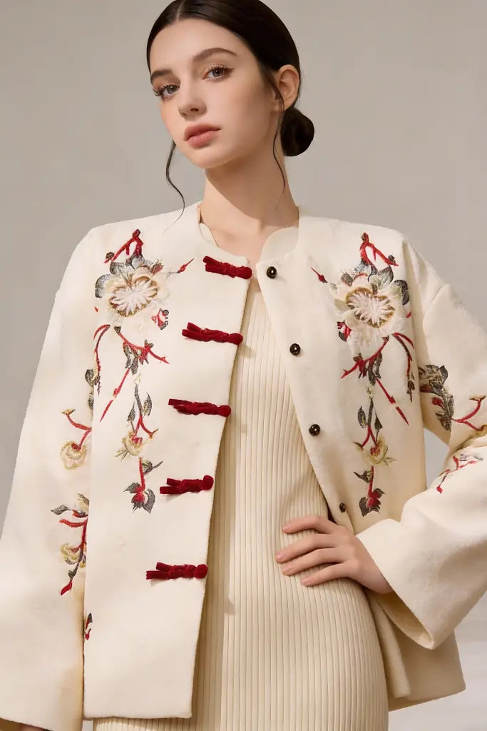 Woman wearing a cream-colored Embroidered Wool Blend Jacket with Floral Patterns & Frog Buttons on a neutral background