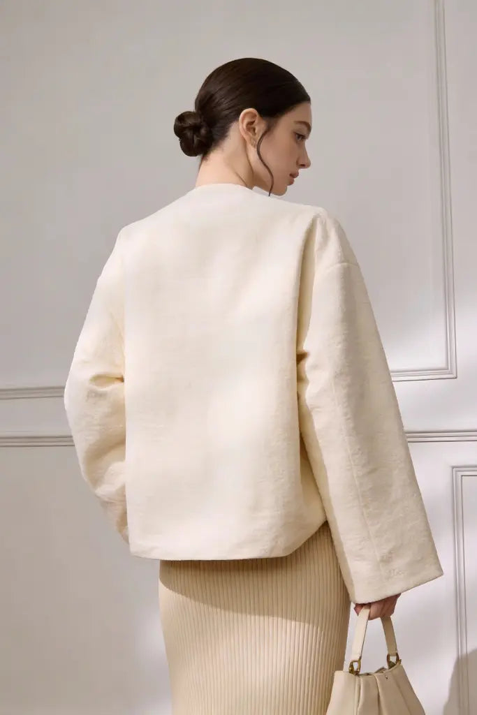 Woman wearing a cream-colored Embroidered Wool Blend Jacket with Floral Patterns & Frog Buttons on a neutral background