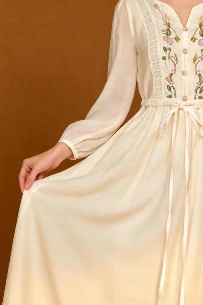 Woman wearing a Romantic Embroidered V-Neck Maxi Dress - White Boho Chic Long Sleeve Evening Gown on a brown background