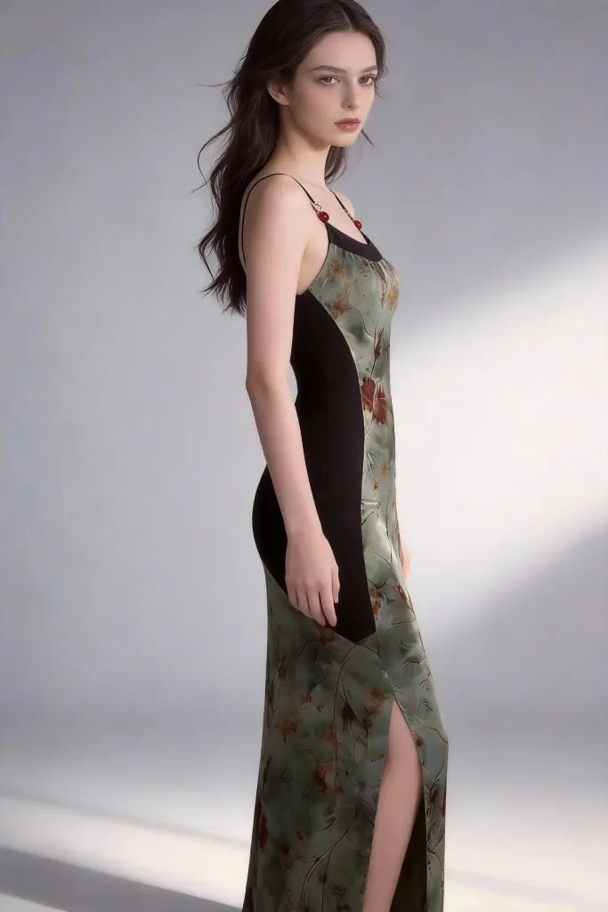 Woman wearing a long, patterned dress with a black overlay on a plain background