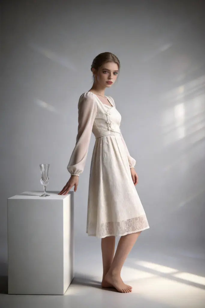 Women wearing a white elegant lace chiffon midi dress with square neck & puff sleeves against a gray background