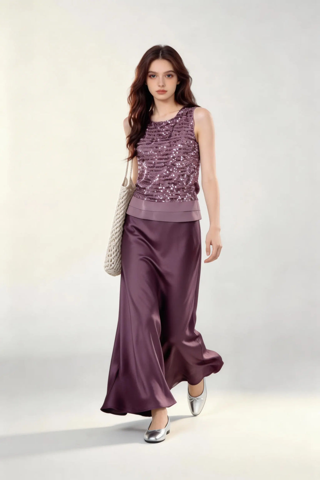 Woman wearing a purple Mauve Sequin Sleeveless Top & Satin Maxi Skirt Set against a white wall.