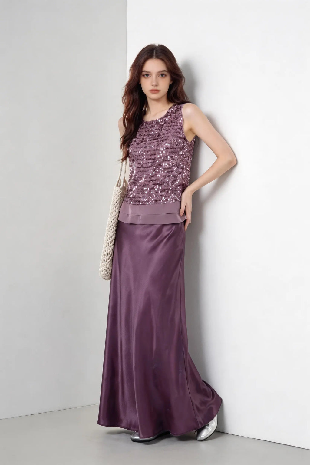 Woman wearing a purple Mauve Sequin Sleeveless Top & Satin Maxi Skirt Set against a white wall.