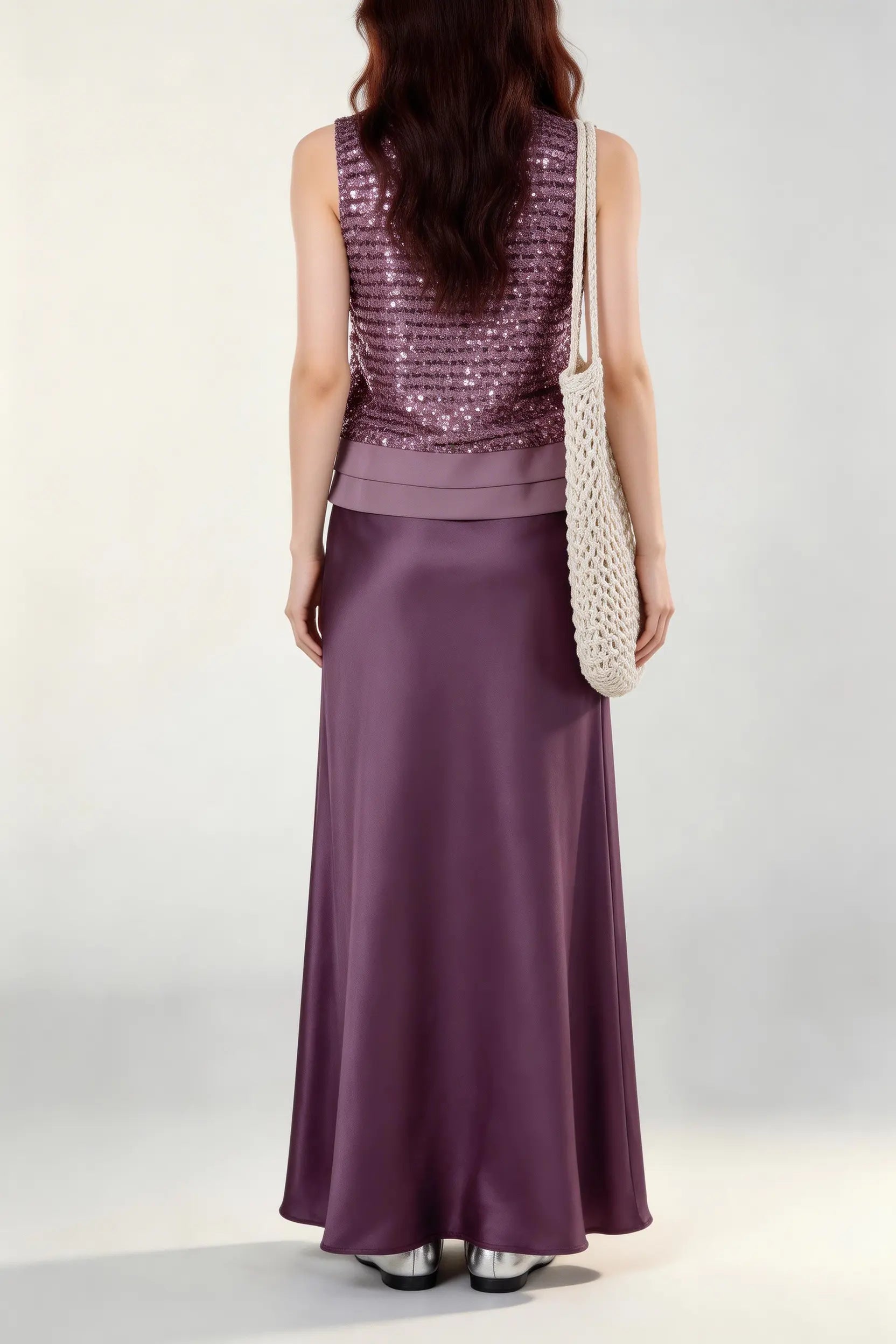 Woman wearing a purple Mauve Sequin Sleeveless Top & Satin Maxi Skirt Set against a white wall.