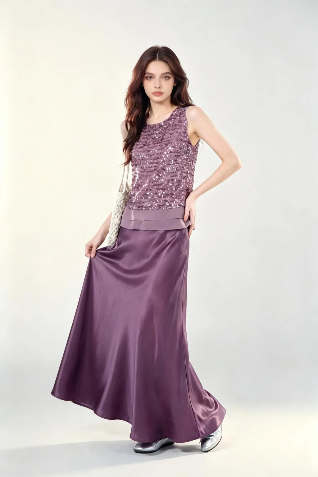 Woman wearing a purple Mauve Sequin Sleeveless Top & Satin Maxi Skirt Set against a white wall.