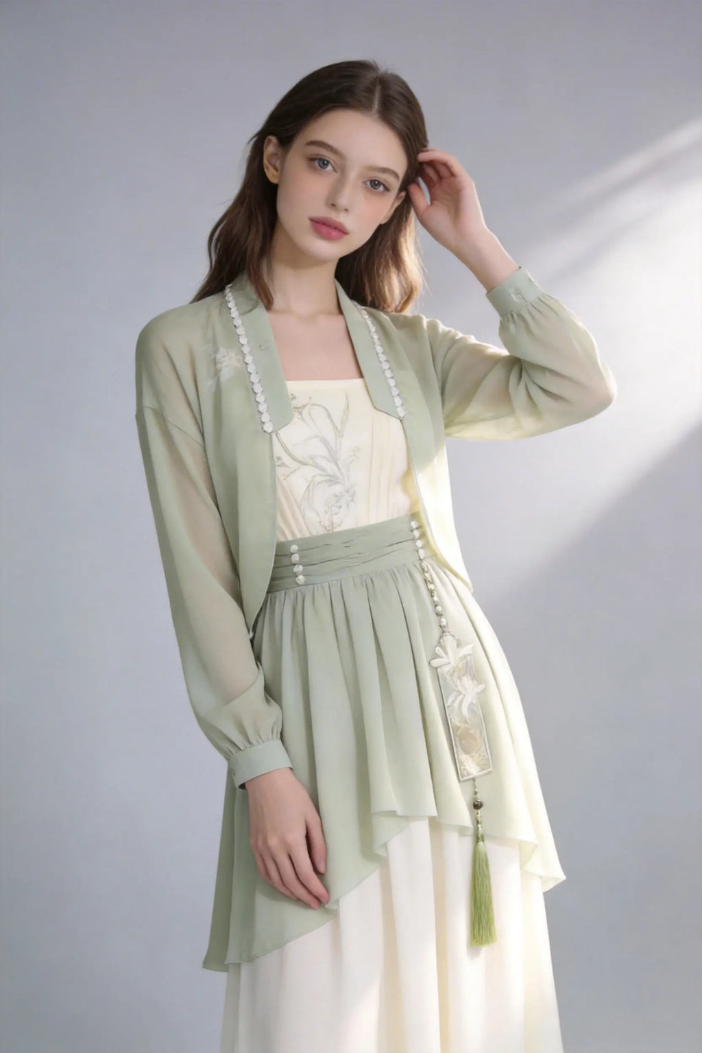Woman wearing a Elegant Sage Green Chiffon Cardigan & Cream Dress Set - Modern Hanfu Inspired Two-Piece Outfit
 on a gray background