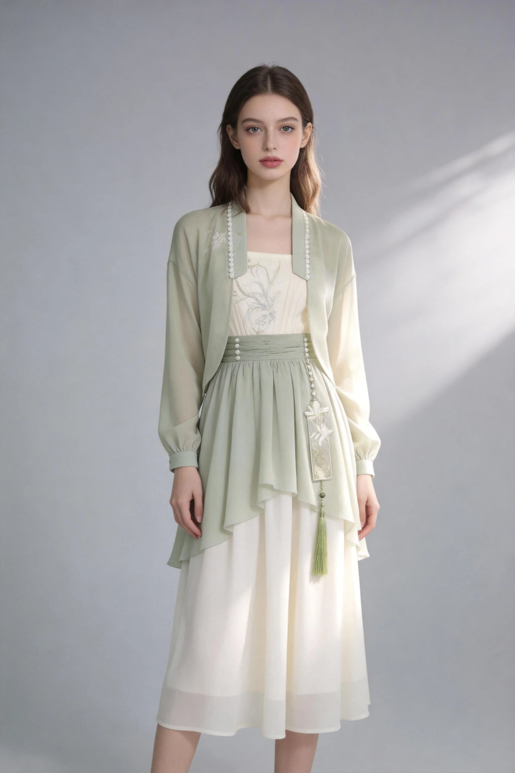 Woman wearing a Elegant Sage Green Chiffon Cardigan & Cream Dress Set - Modern Hanfu Inspired Two-Piece Outfit
 on a gray background