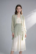 Woman wearing a Elegant Sage Green Chiffon Cardigan & Cream Dress Set - Modern Hanfu Inspired Two-Piece Outfit
 on a gray background