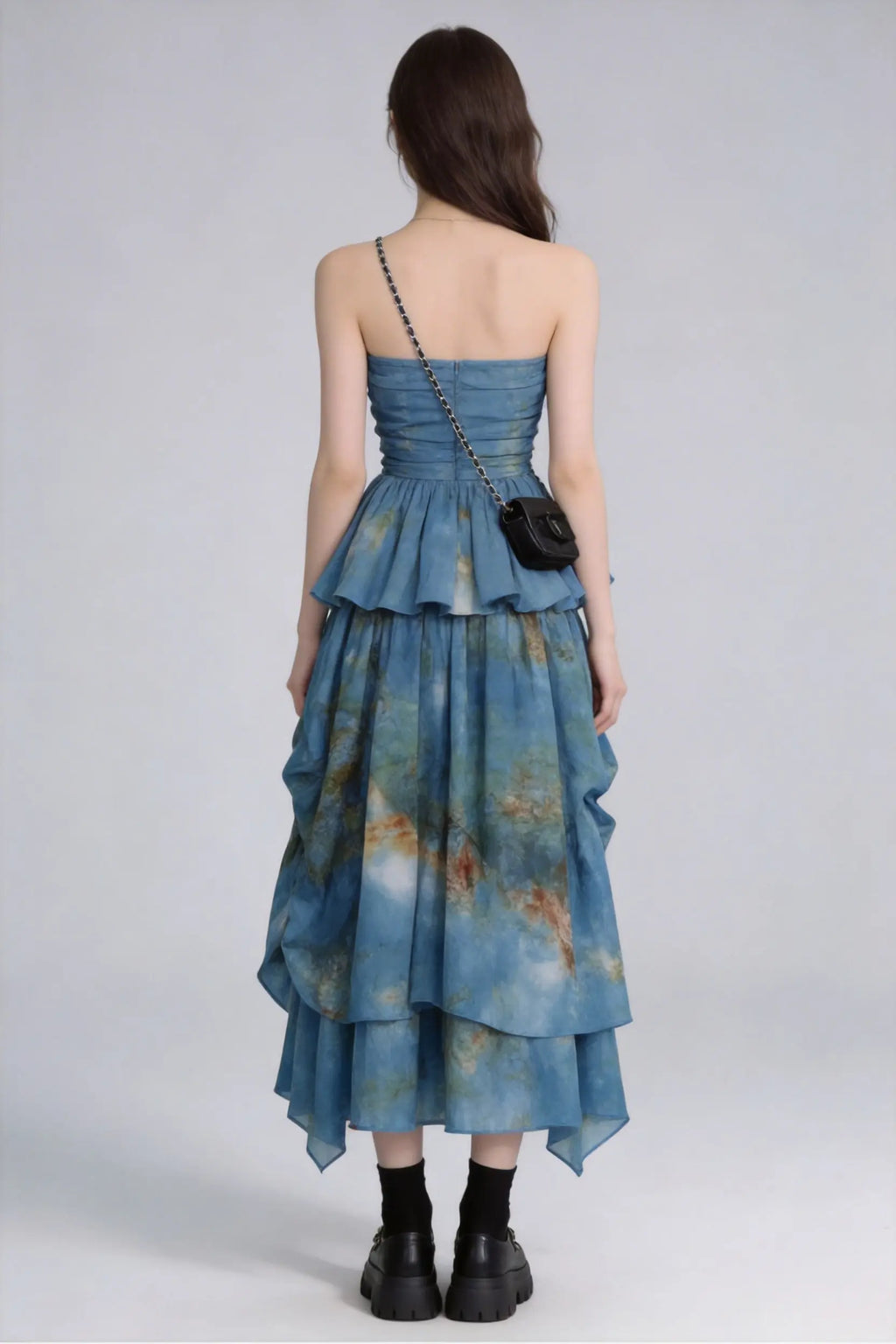Woman wearing a Tie-Dye Blue Strapless Ruffle Top & Asymmetric Maxi Skirt Two-Piece Set with a plain background