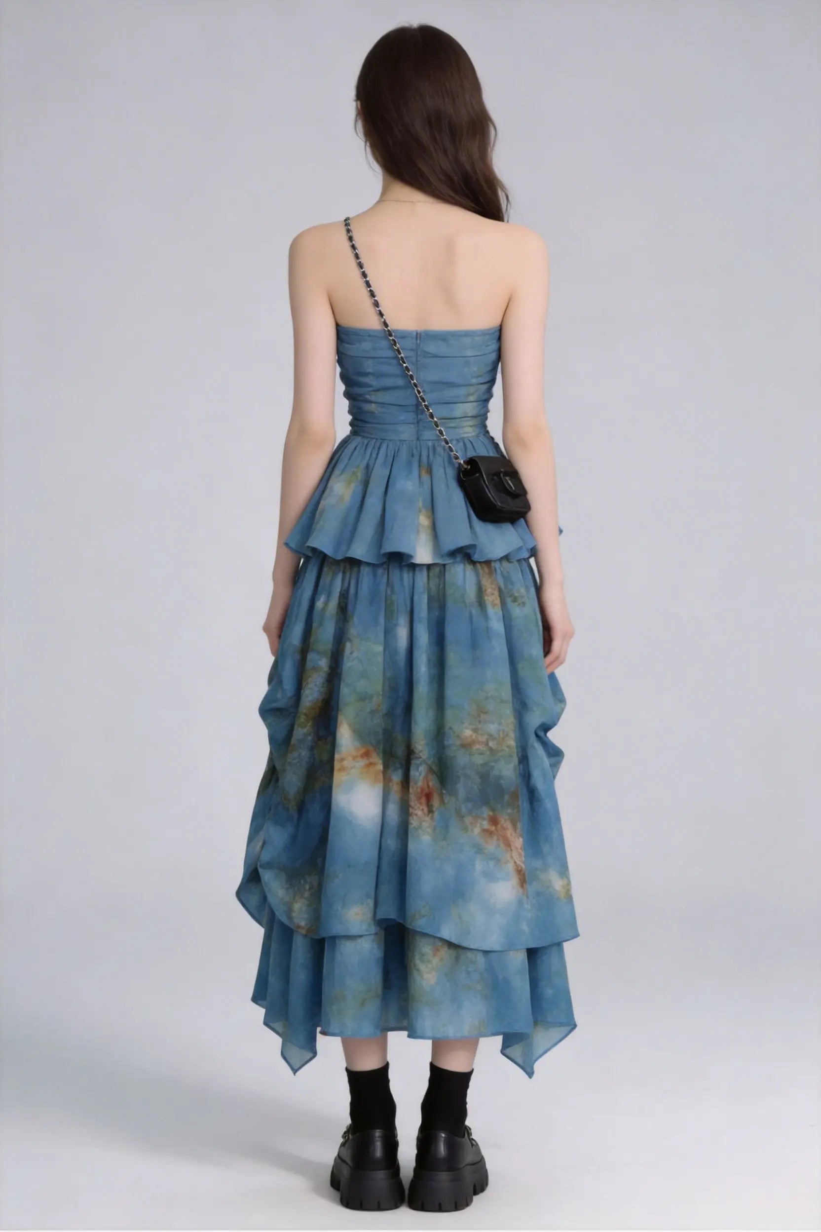Woman wearing a Tie-Dye Blue Strapless Ruffle Top & Asymmetric Maxi Skirt Two-Piece Set with a plain background