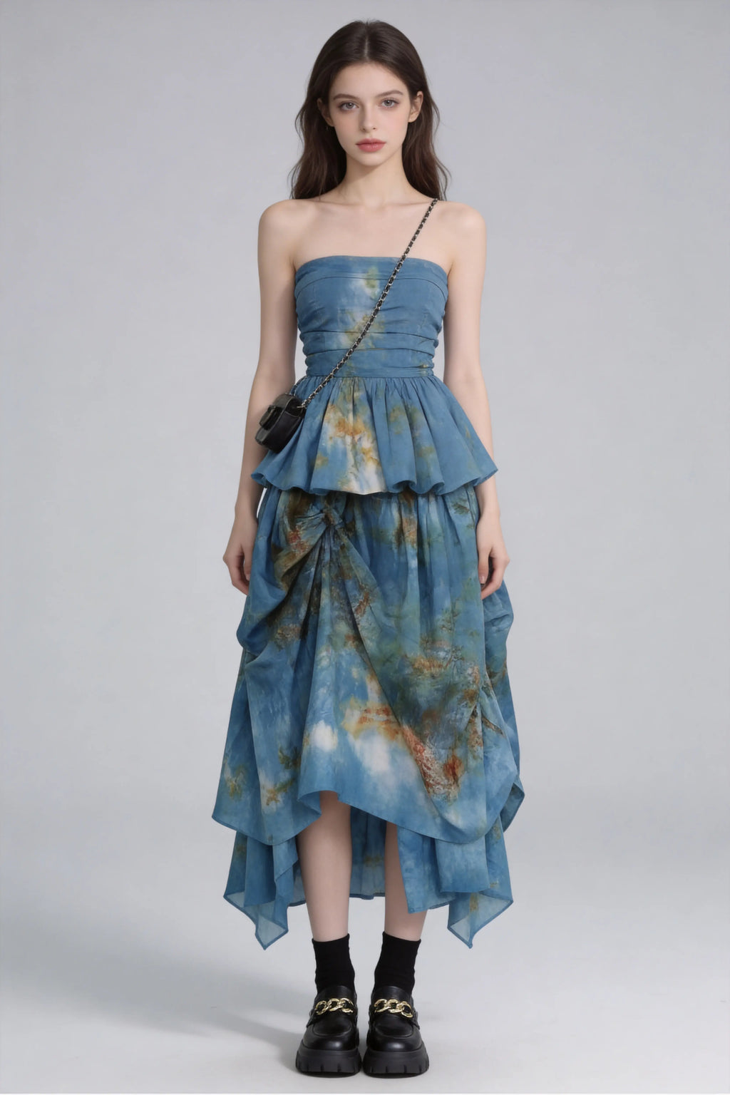 Woman wearing a Tie-Dye Blue Strapless Ruffle Top & Asymmetric Maxi Skirt Two-Piece Set with a plain background