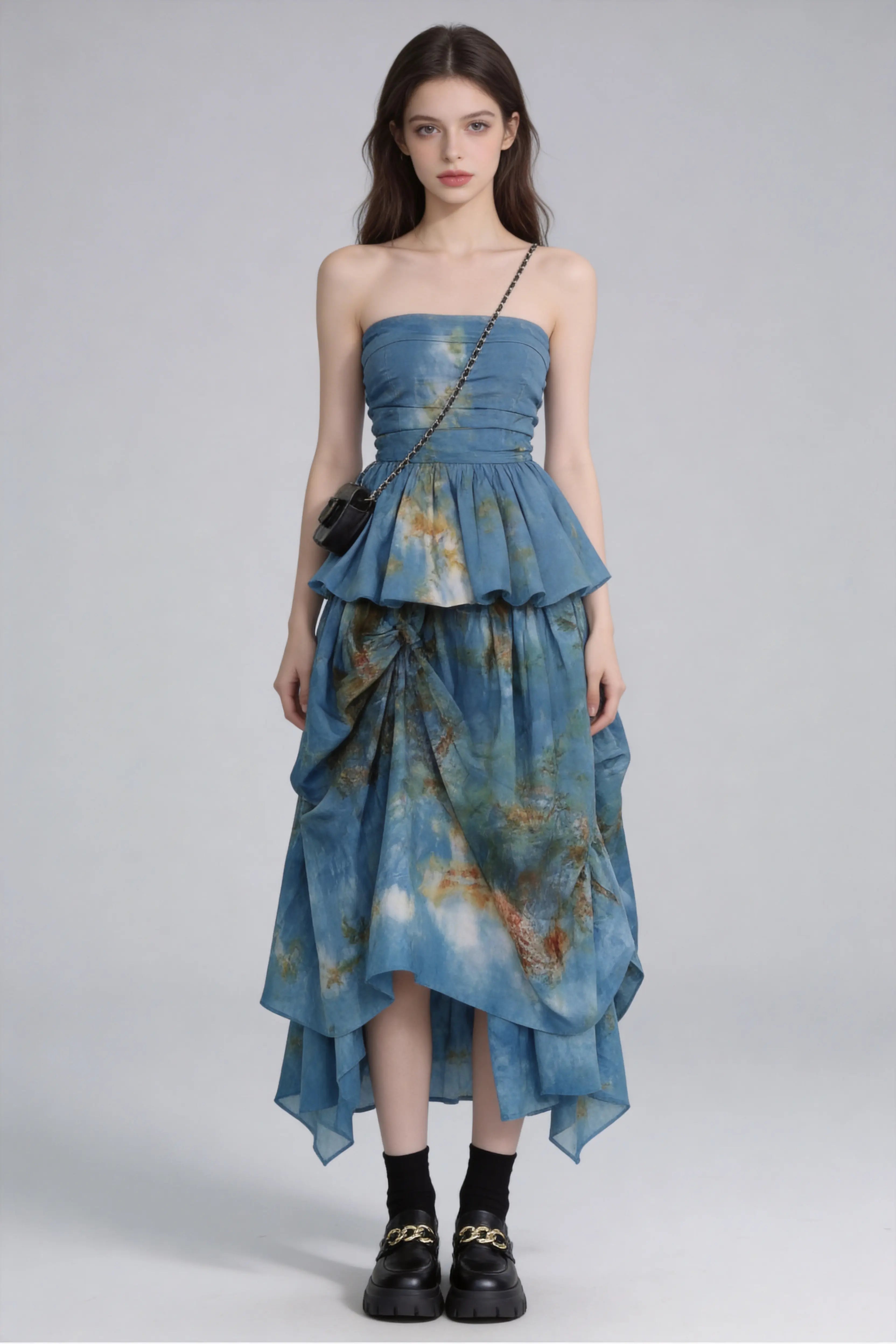 Woman wearing a Tie-Dye Blue Strapless Ruffle Top & Asymmetric Maxi Skirt Two-Piece Set with a plain background