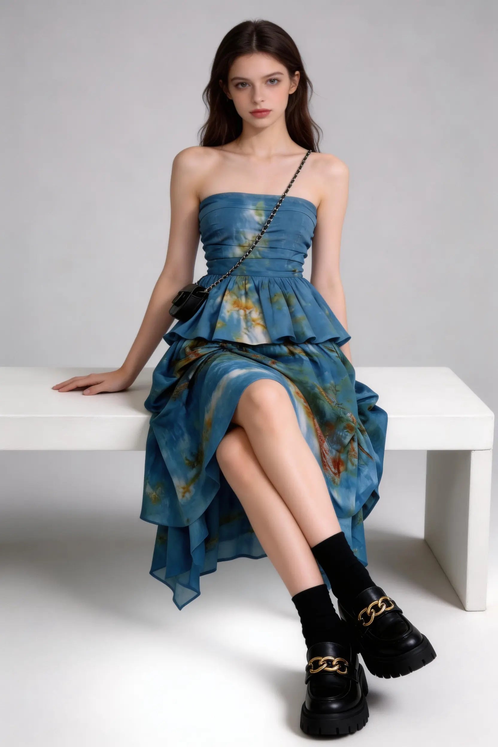 Woman wearing a Tie-Dye Blue Strapless Ruffle Top & Asymmetric Maxi Skirt Two-Piece Set with a plain background