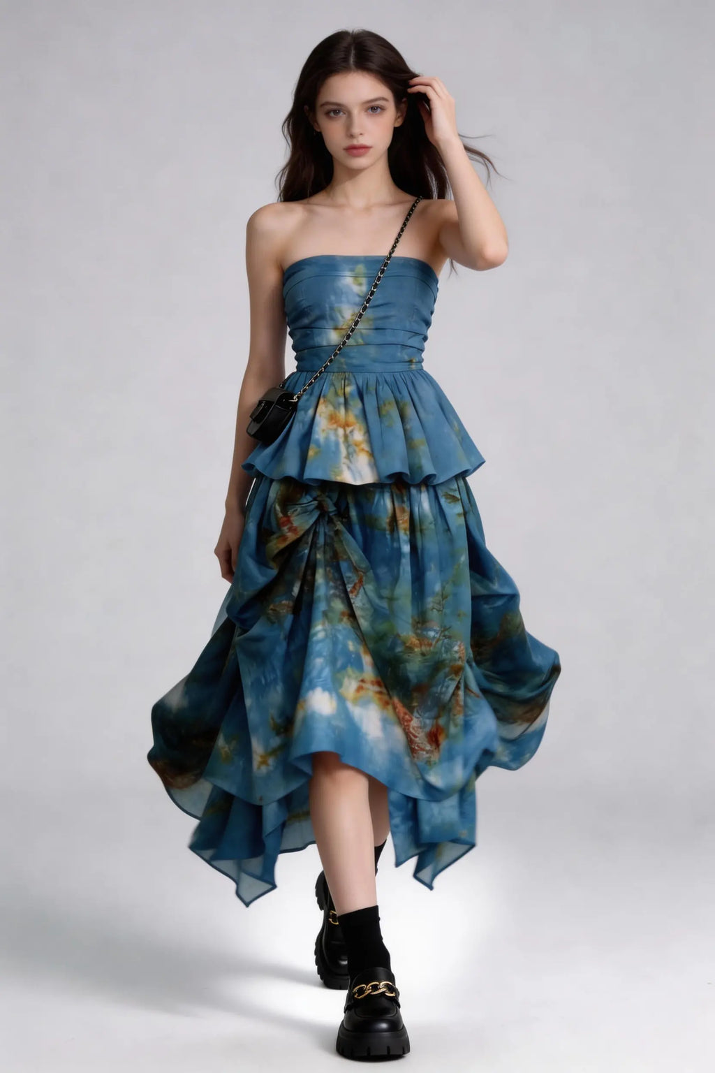Woman wearing a Tie-Dye Blue Strapless Ruffle Top & Asymmetric Maxi Skirt Two-Piece Set with a plain background