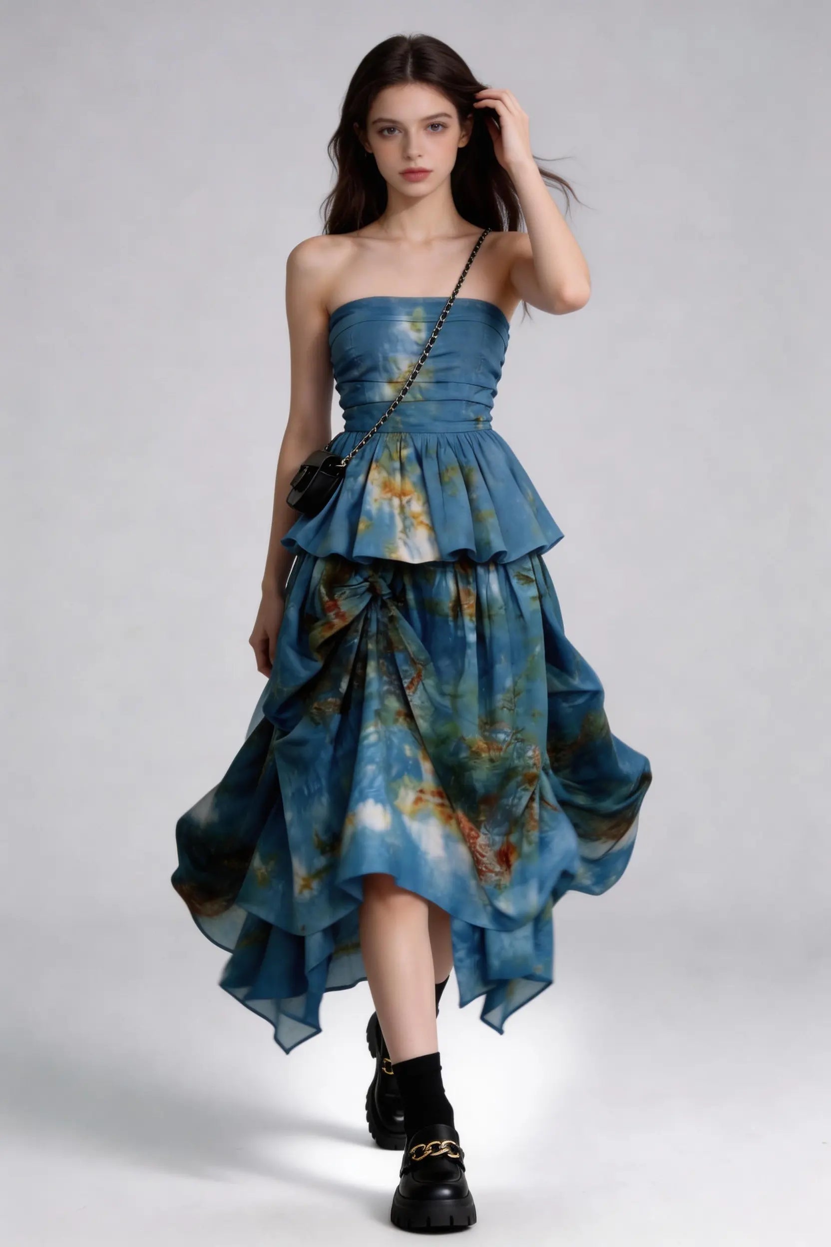 Woman wearing a Tie-Dye Blue Strapless Ruffle Top & Asymmetric Maxi Skirt Two-Piece Set with a plain background