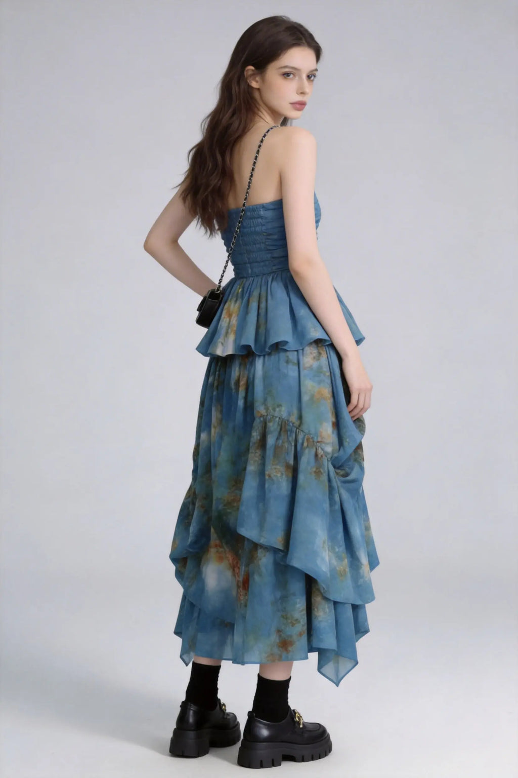 Woman wearing a Tie-Dye Blue Strapless Ruffle Top & Asymmetric Maxi Skirt Two-Piece Set with a plain background
