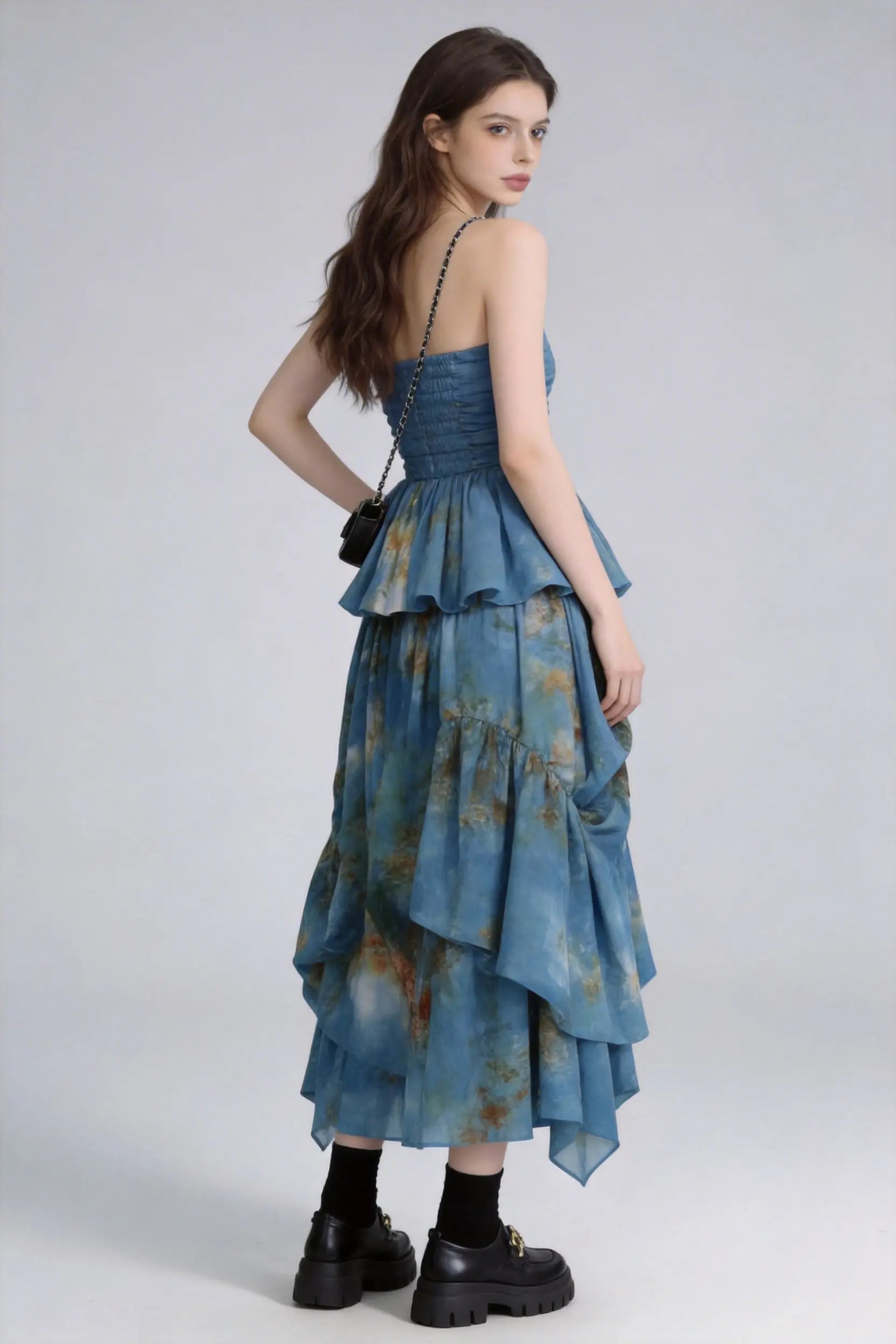 Woman wearing a Tie-Dye Blue Strapless Ruffle Top & Asymmetric Maxi Skirt Two-Piece Set with a plain background