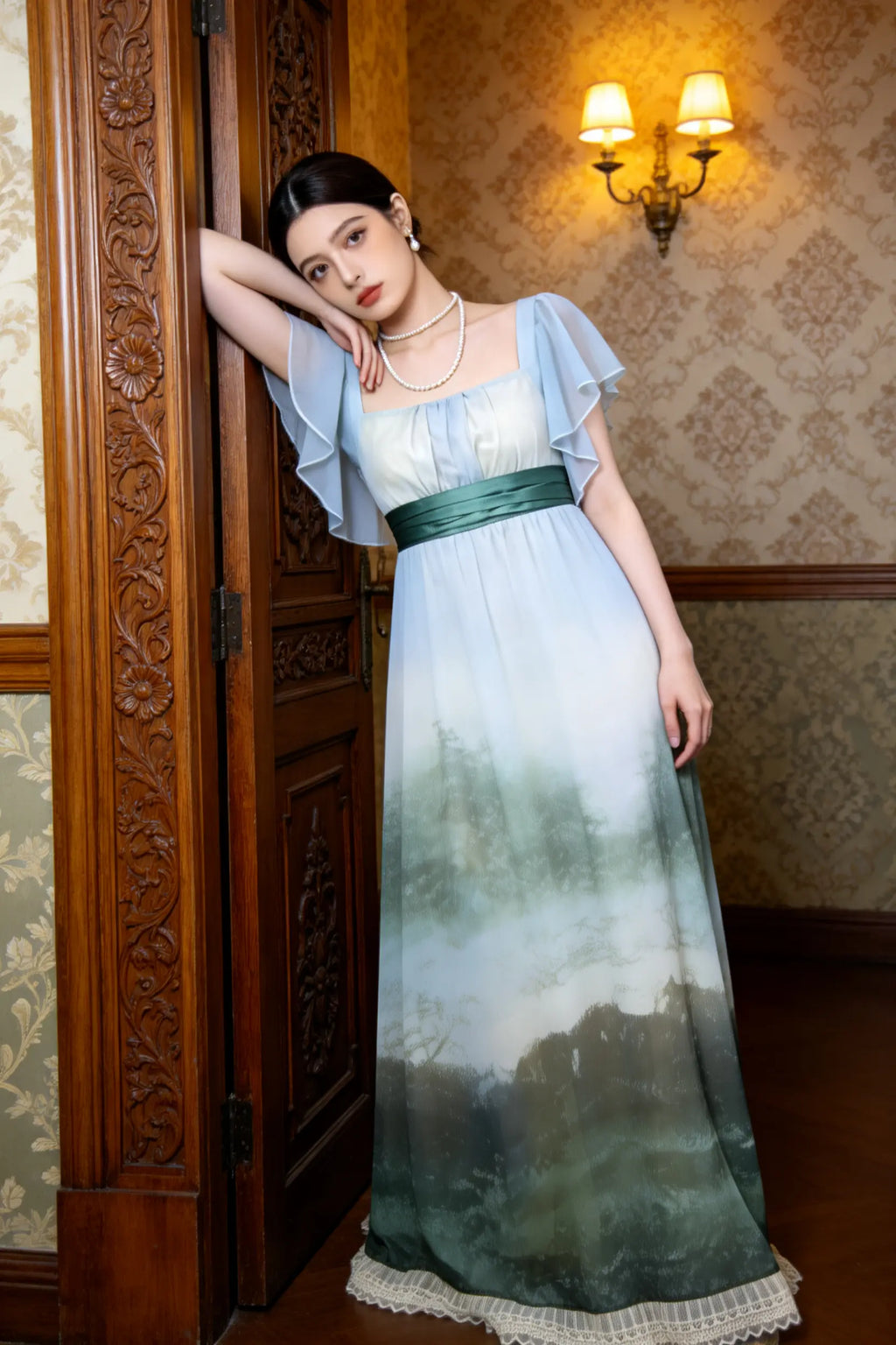 Woman wearing a green Vintage Ombr¨¦ Empire Waist Gown with Ruffled Sleeves and Back Bow on a gray background