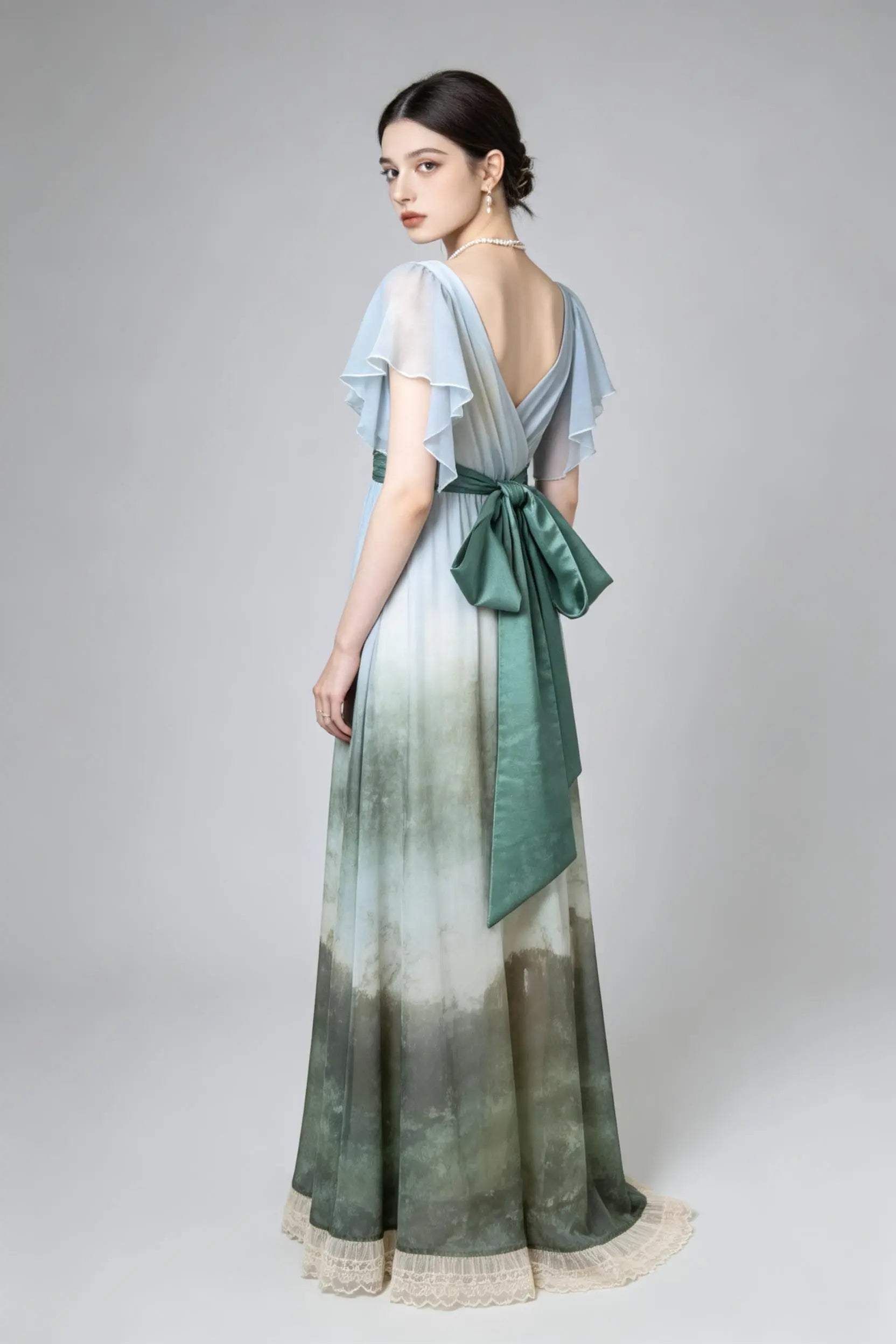 Woman wearing a green Vintage Ombr¨¦ Empire Waist Gown with Ruffled Sleeves and Back Bow on a gray background