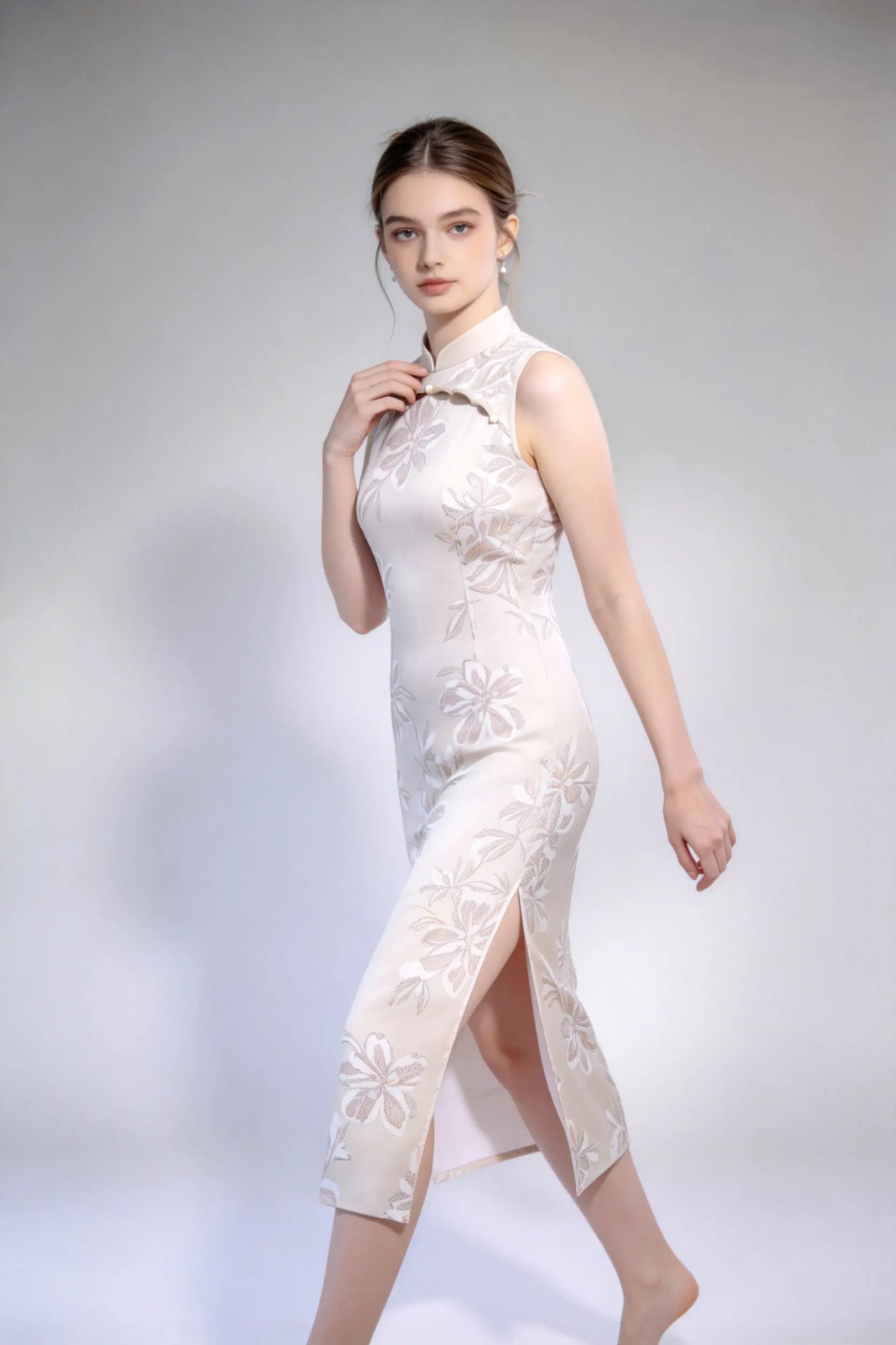 Woman wearing sleeveless floral embroidery cheongsam with cutout frog buttons, double-lined mandarin collar qipao dress against a plain background