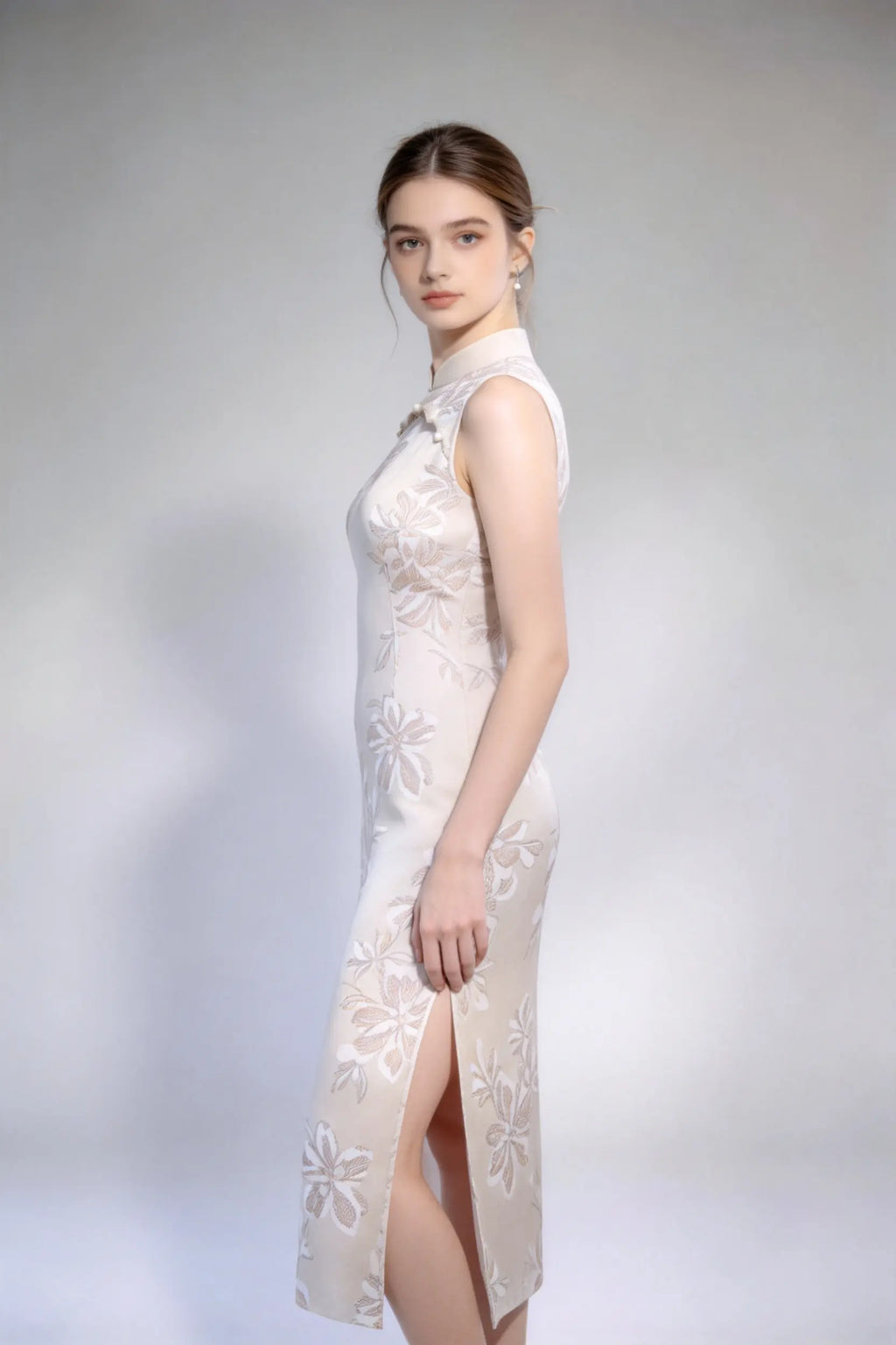 Woman wearing sleeveless floral embroidery cheongsam with cutout frog buttons, double-lined mandarin collar qipao dress against a plain background