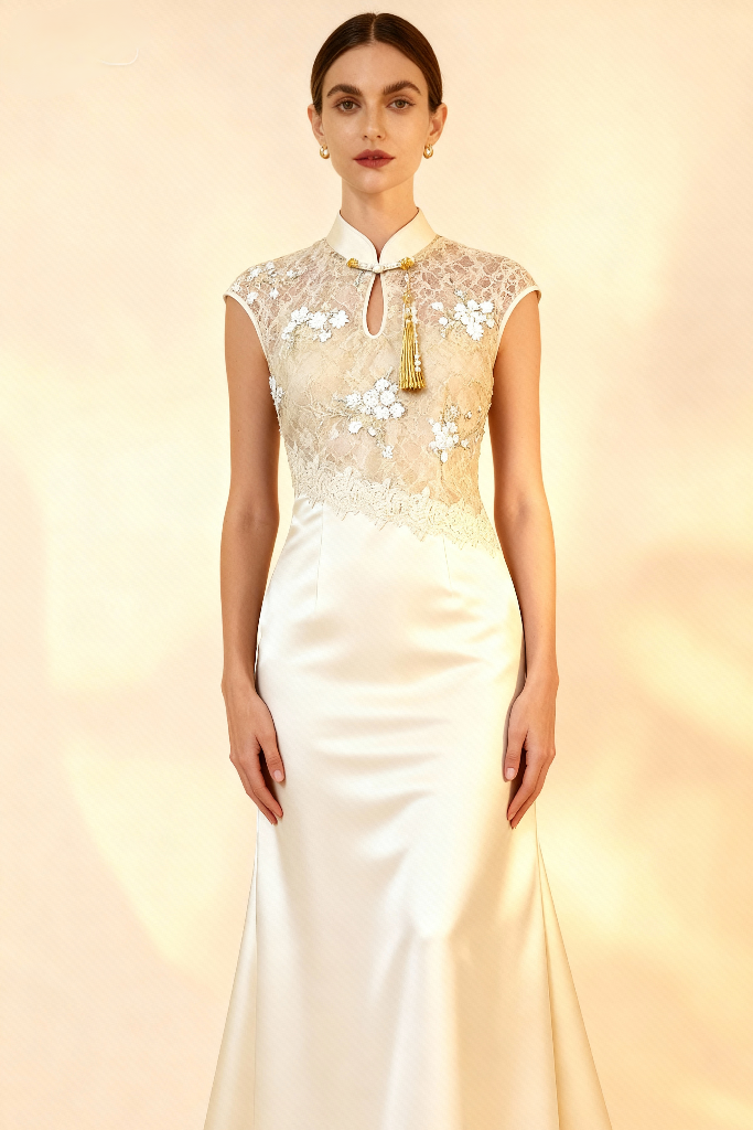 Woman wearing a white evening gown with floral lace top on a beige background