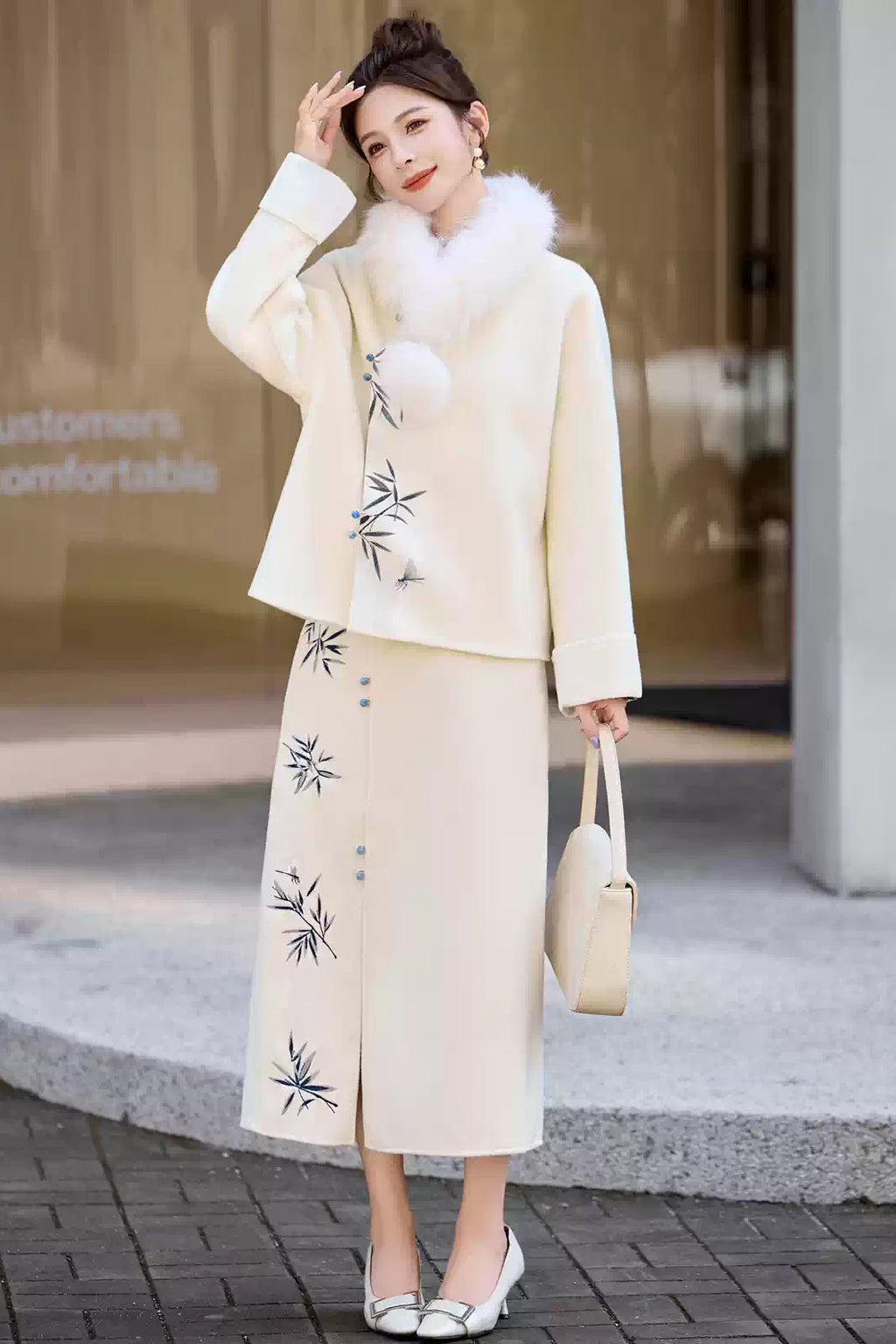 Woman in a Traditional Chinese Bamboo Embroidered Coat & Skirt Set - white, holding a handbag, standing outdoors.