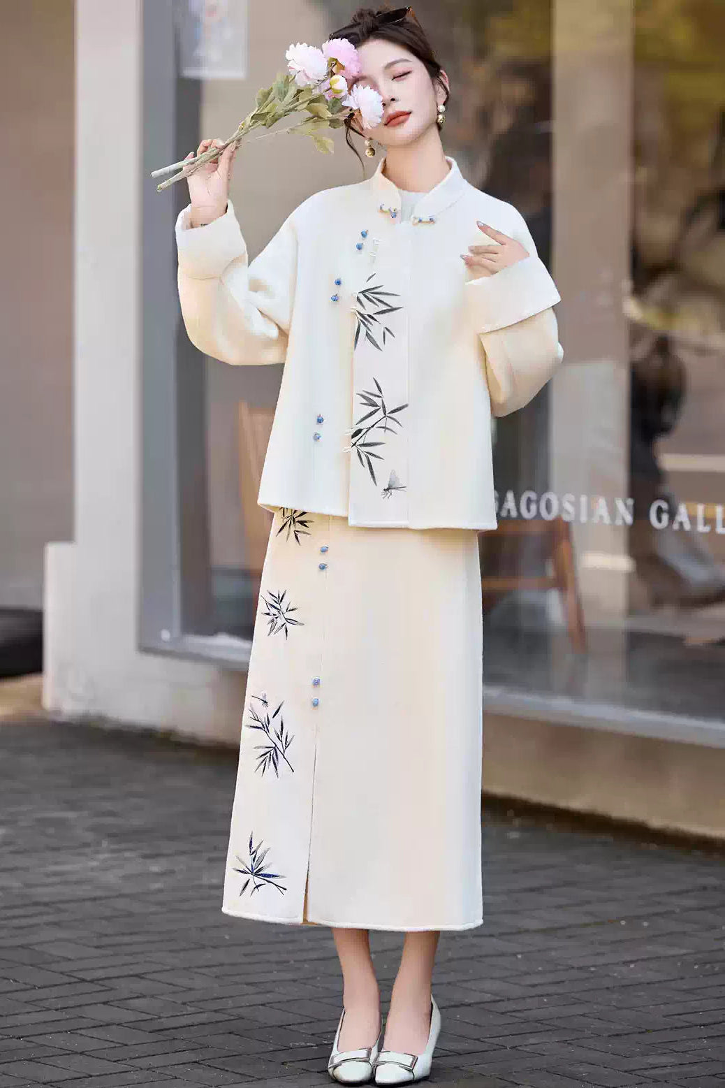 Woman in a Traditional Chinese Bamboo Embroidered Coat & Skirt Set - white, holding a handbag, standing outdoors.