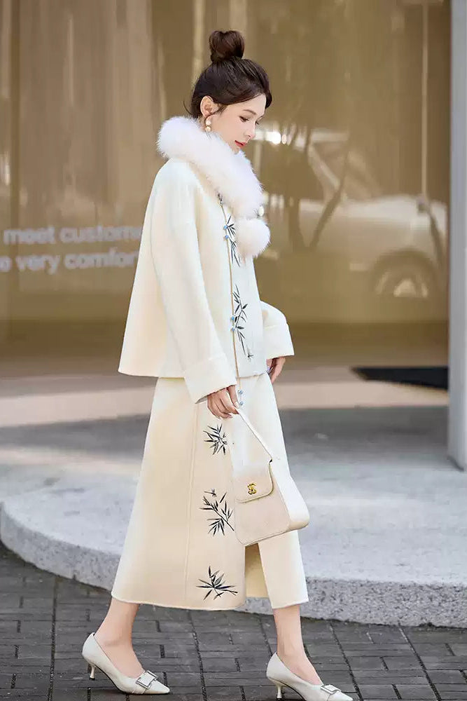 Woman in a Traditional Chinese Bamboo Embroidered Coat & Skirt Set - white, holding a handbag, standing outdoors.